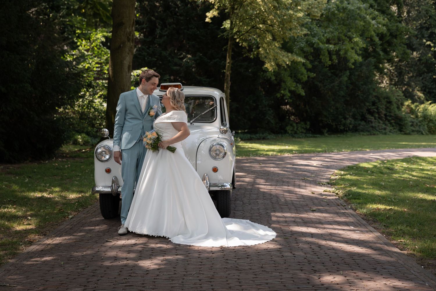 Aankomst in de trouwauto spontaan vastgelegd – bruiloftsfotografie vanuit Eindhoven, Noord-Brabant, door heel Nederland en buitenland.