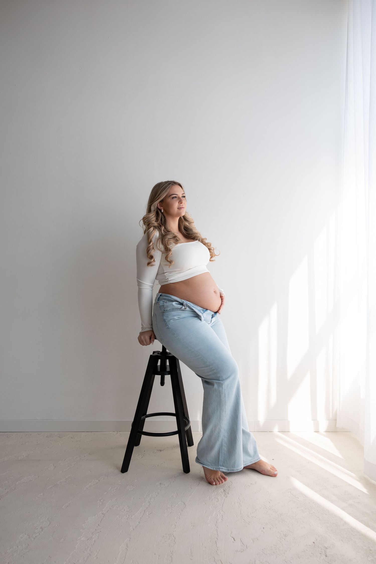 Zwangerschapsshoot in Noord-Brabant met een elegante aanstaande moeder in een minimalistische studio.