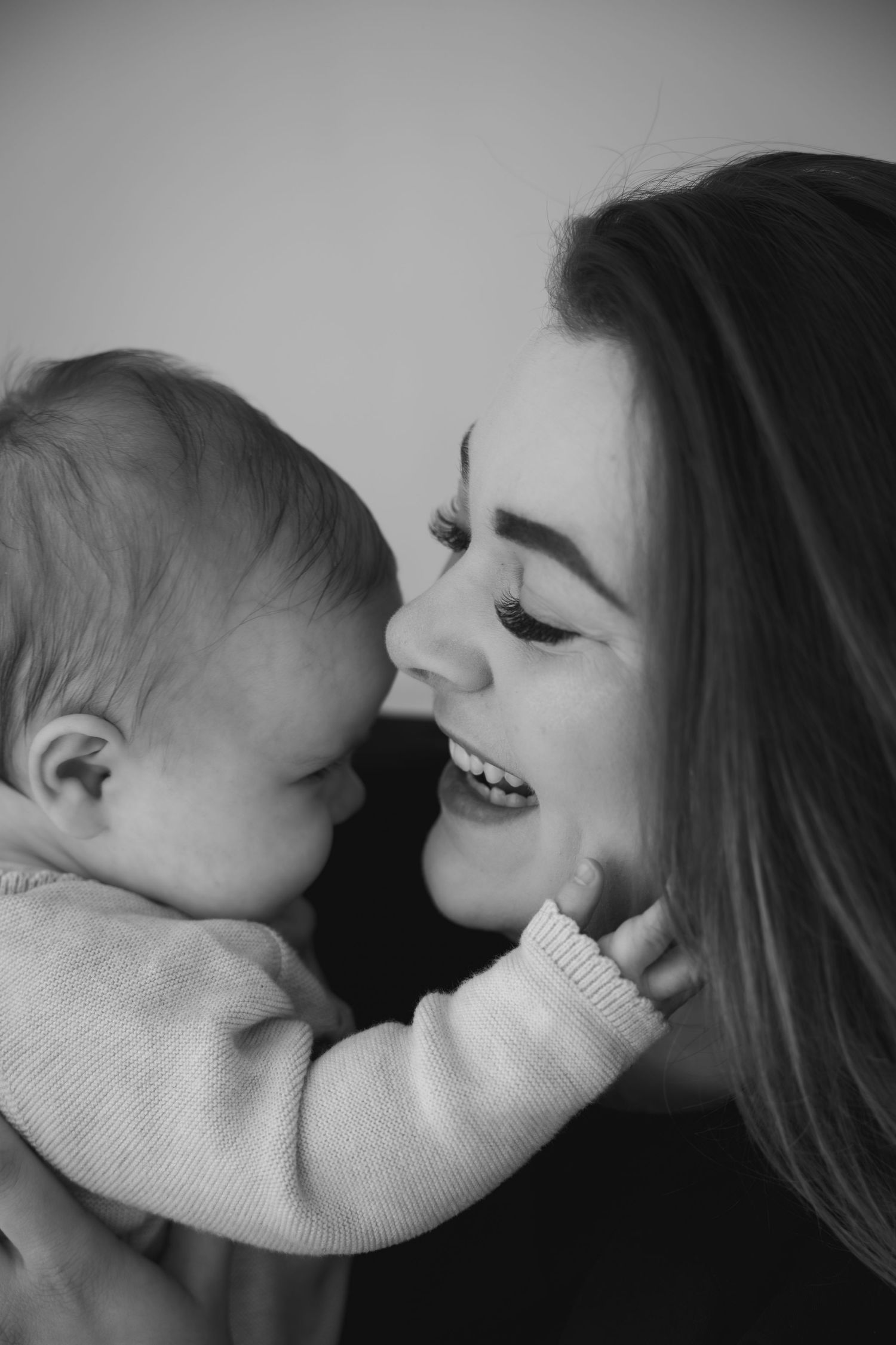 Motherhood fotoshoot in Eindhoven waarbij moeder en kindje liefdevolle momenten delen in een lichte studio.