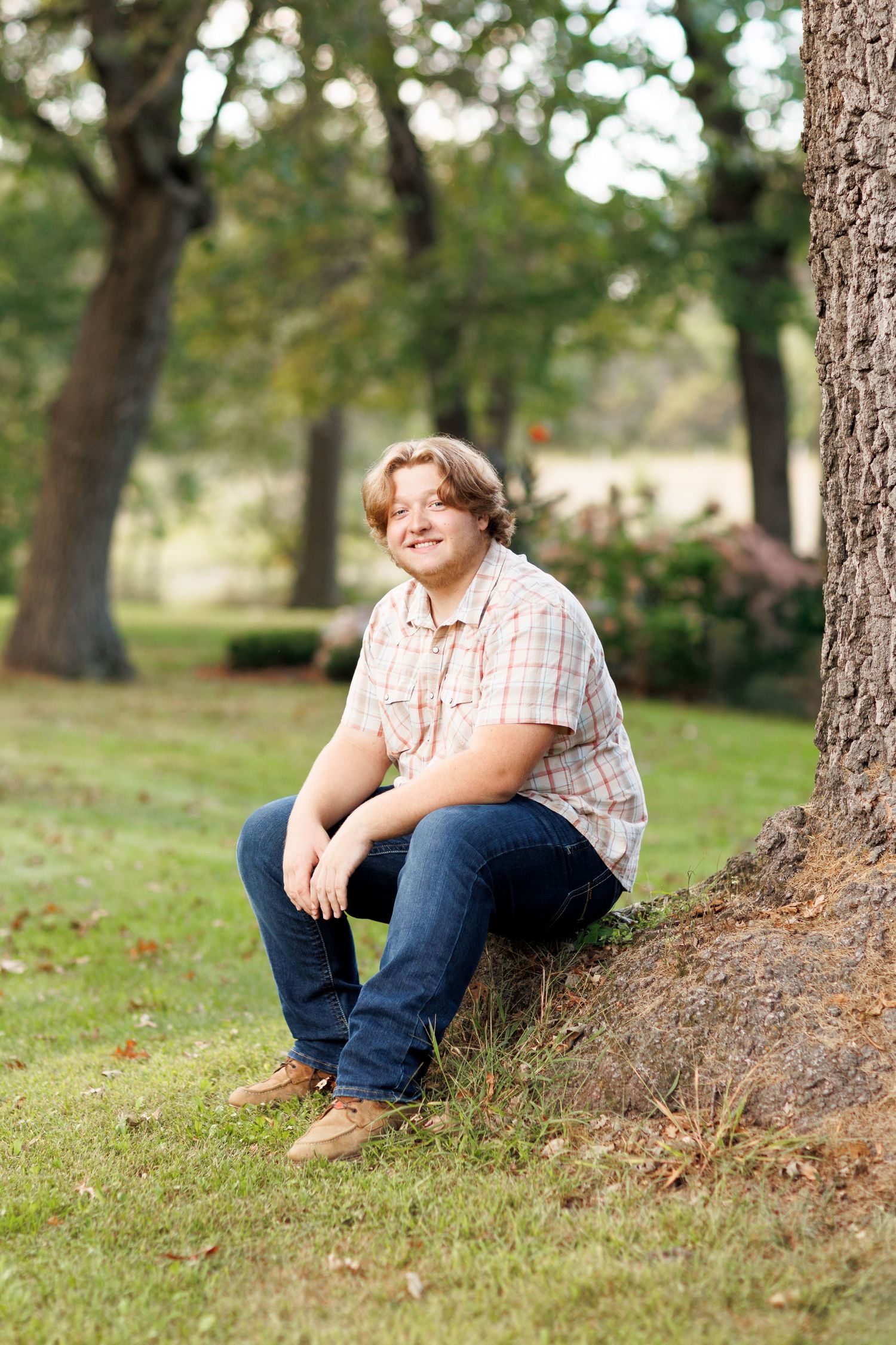 Casual outdoor senior session in a park with trees and natural lighting.