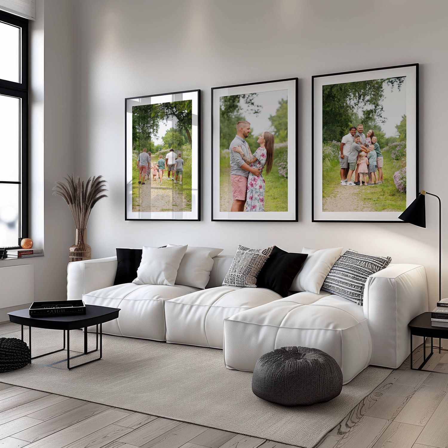 Modern minimalist living room with white sectional sofa, black accents, and framed family photo gallery wall display.