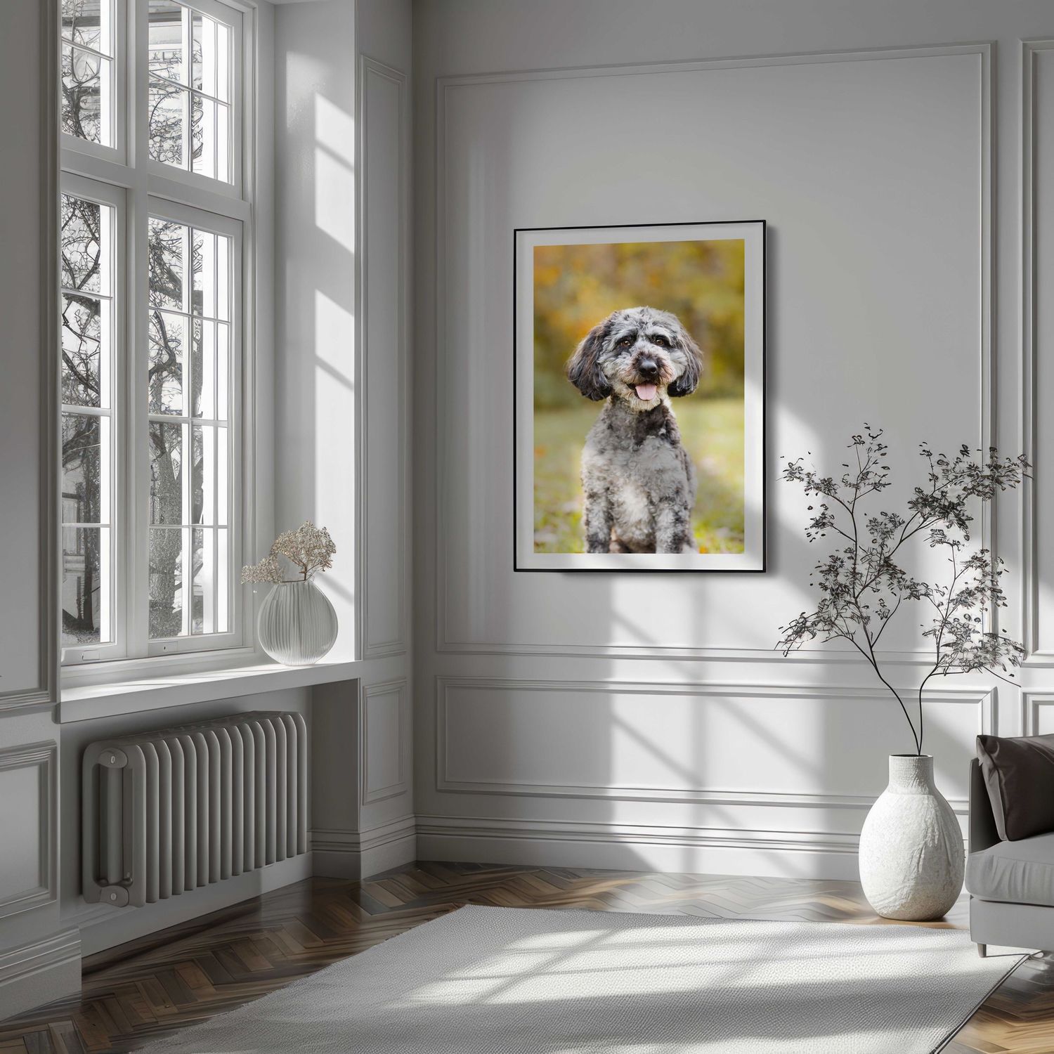 Bright modern interior with white walls, tall windows, and minimalist decor featuring a framed dog portrait.
