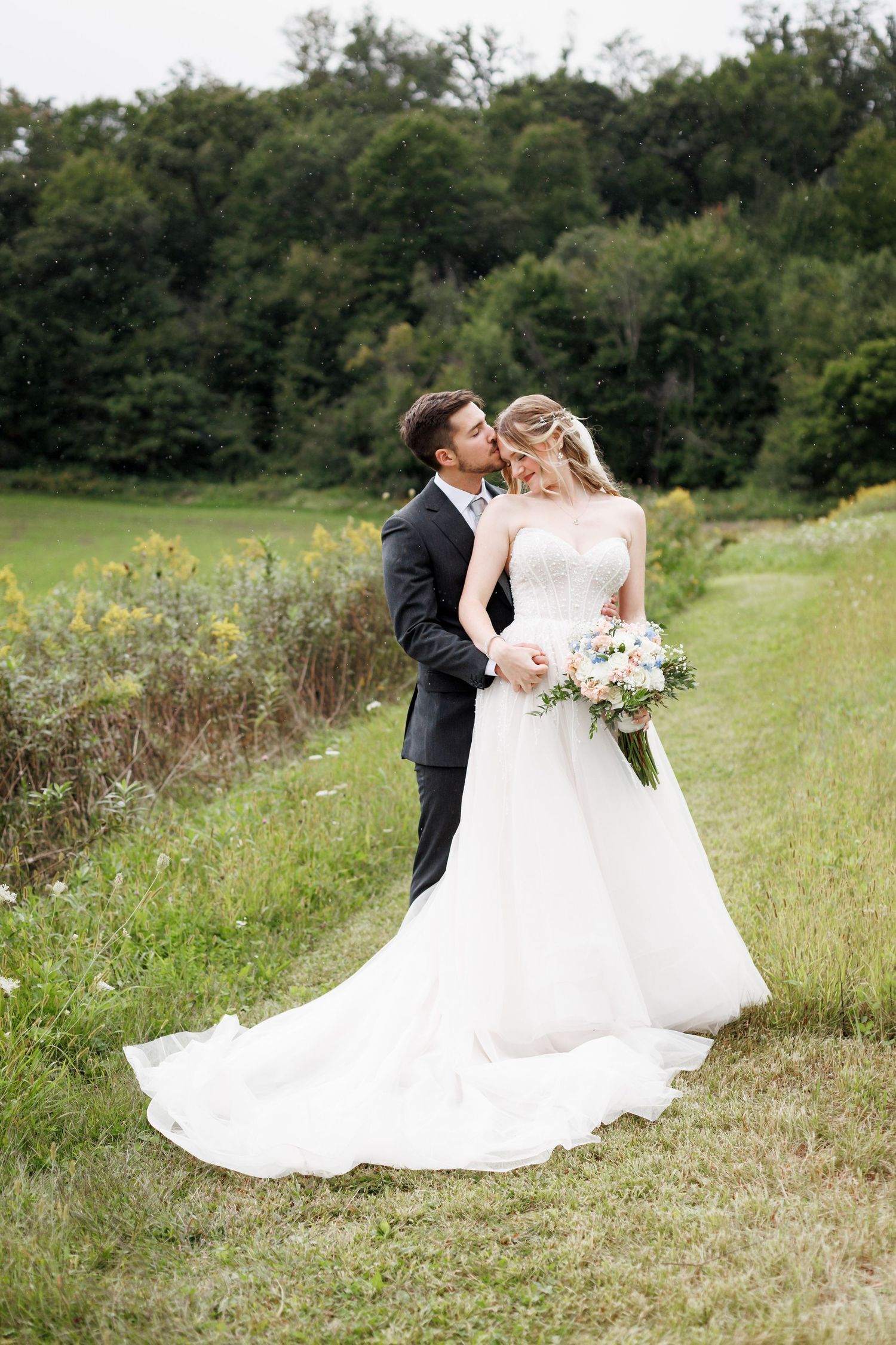 Romantic wedding photos in a meadow with flowing white dress.