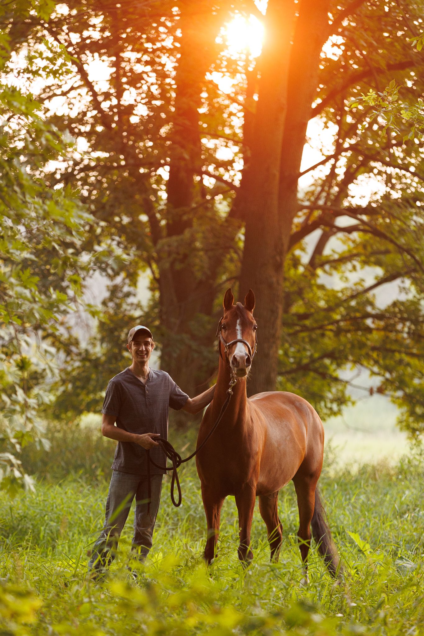 Unedited portrait of a guy and his horse in a sunny forest