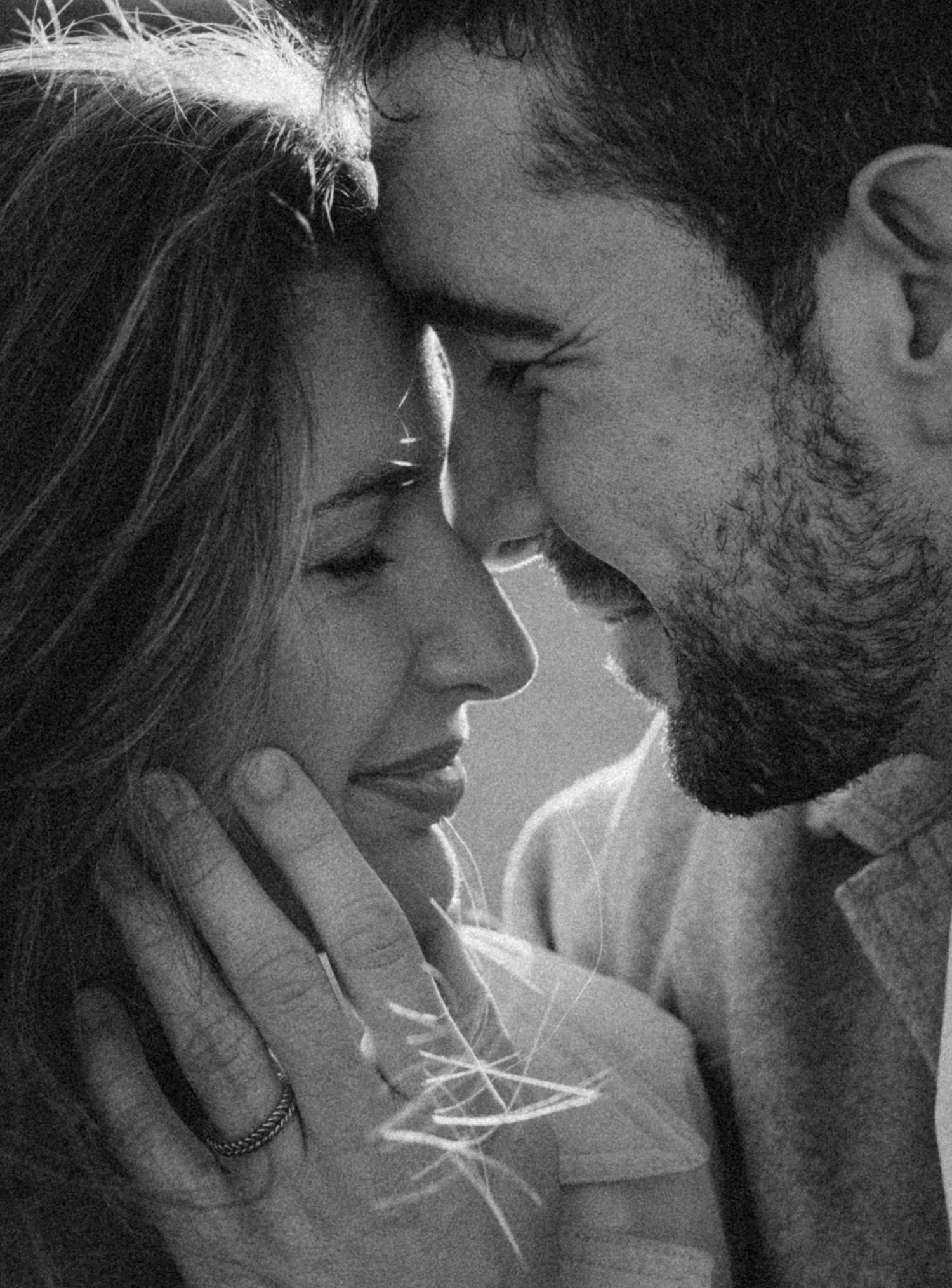 A romantic black and white photo series showing intimate close-up moments between a couple in soft lighting. Photographer Javea