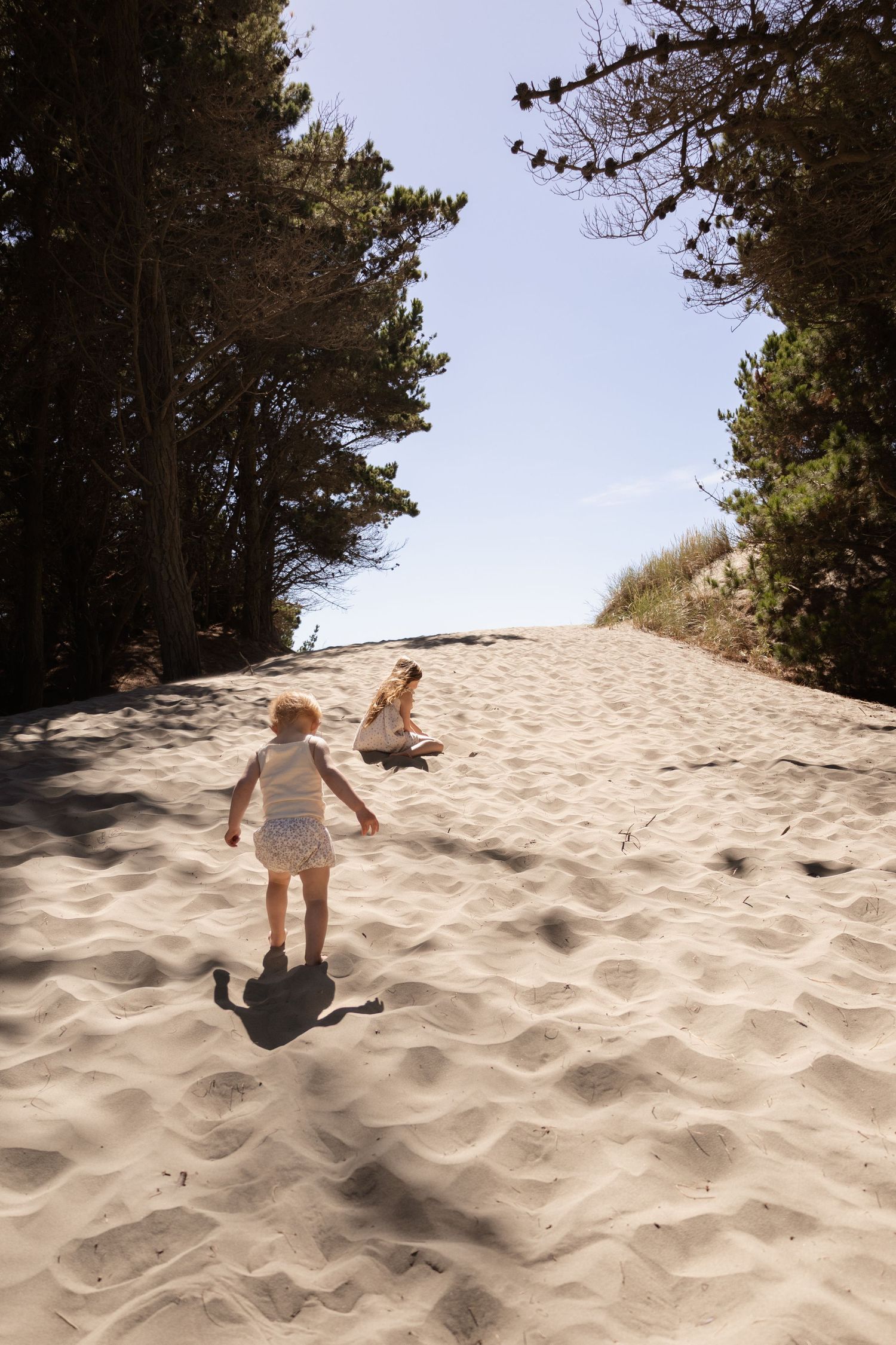 Kids playing and having fun in the sand during family session at the beach.