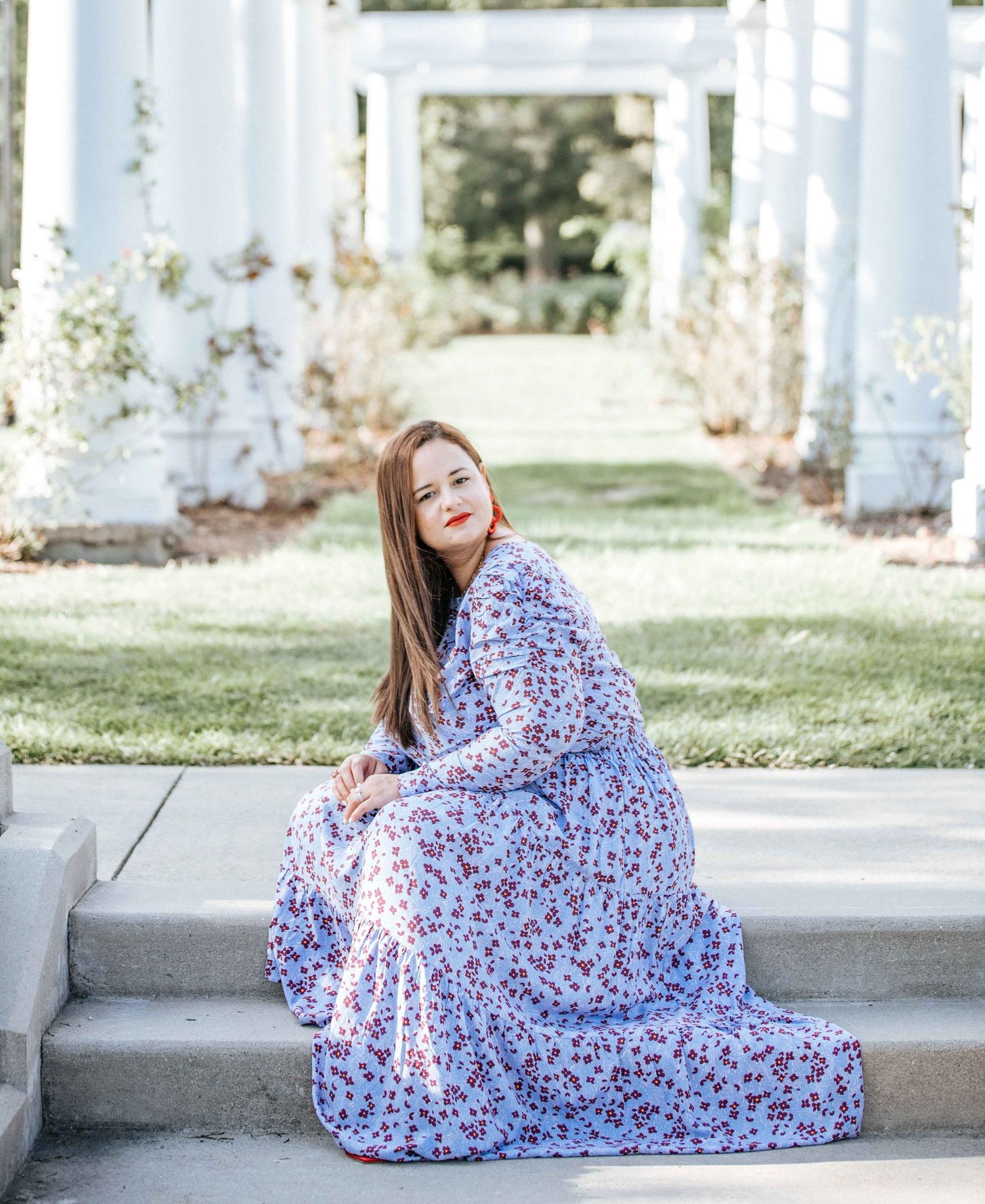 Series of elegant portraits under white pergola featuring flowing floral dress.