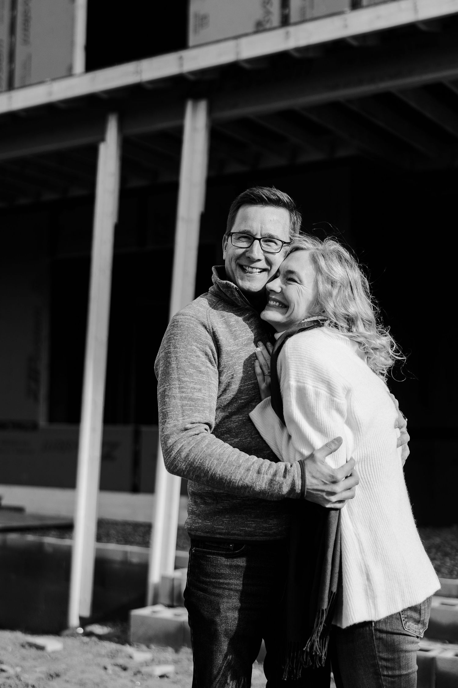 A sequence of black and white photos showing a tender embrace between two people in winter clothing.