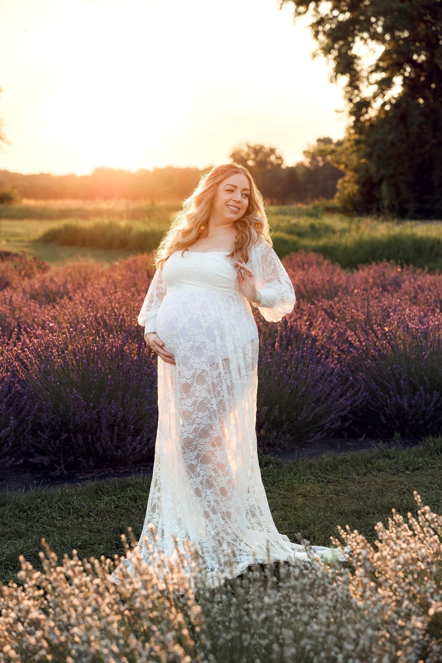 Pregnant woman poses during golden hour in a lavender field. Milan MI lavender photographer. Metro Detroit Maternity Photographer.