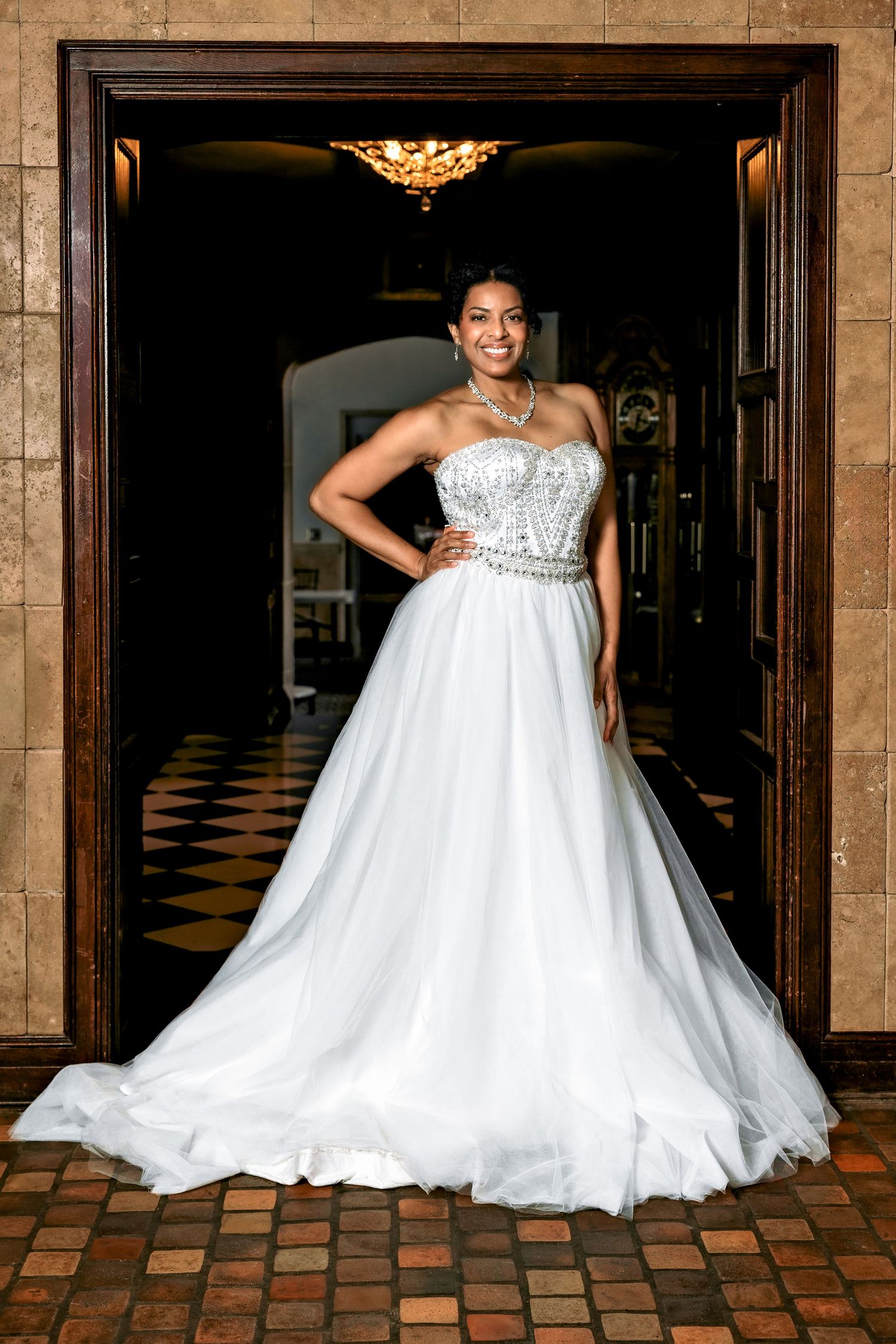 A stunning bride in a flowing white ballgown twirls and poses in an elegant hotel hallway with ornate decor.