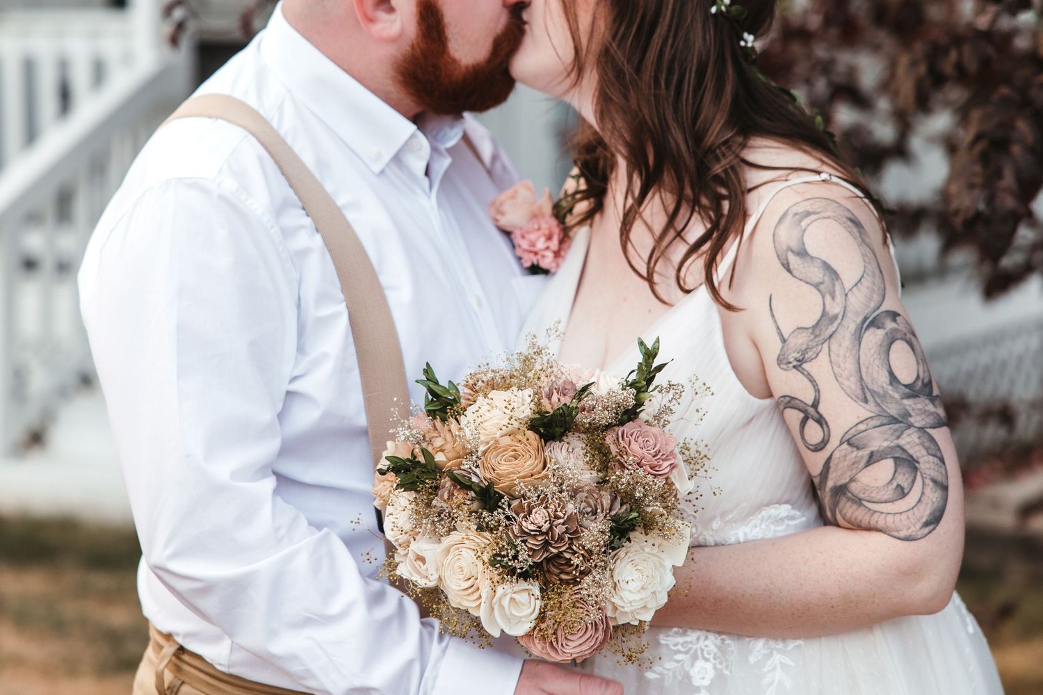 Couple kisses on their wedding day with close up of bouquet. Michigan Wedding Photographer