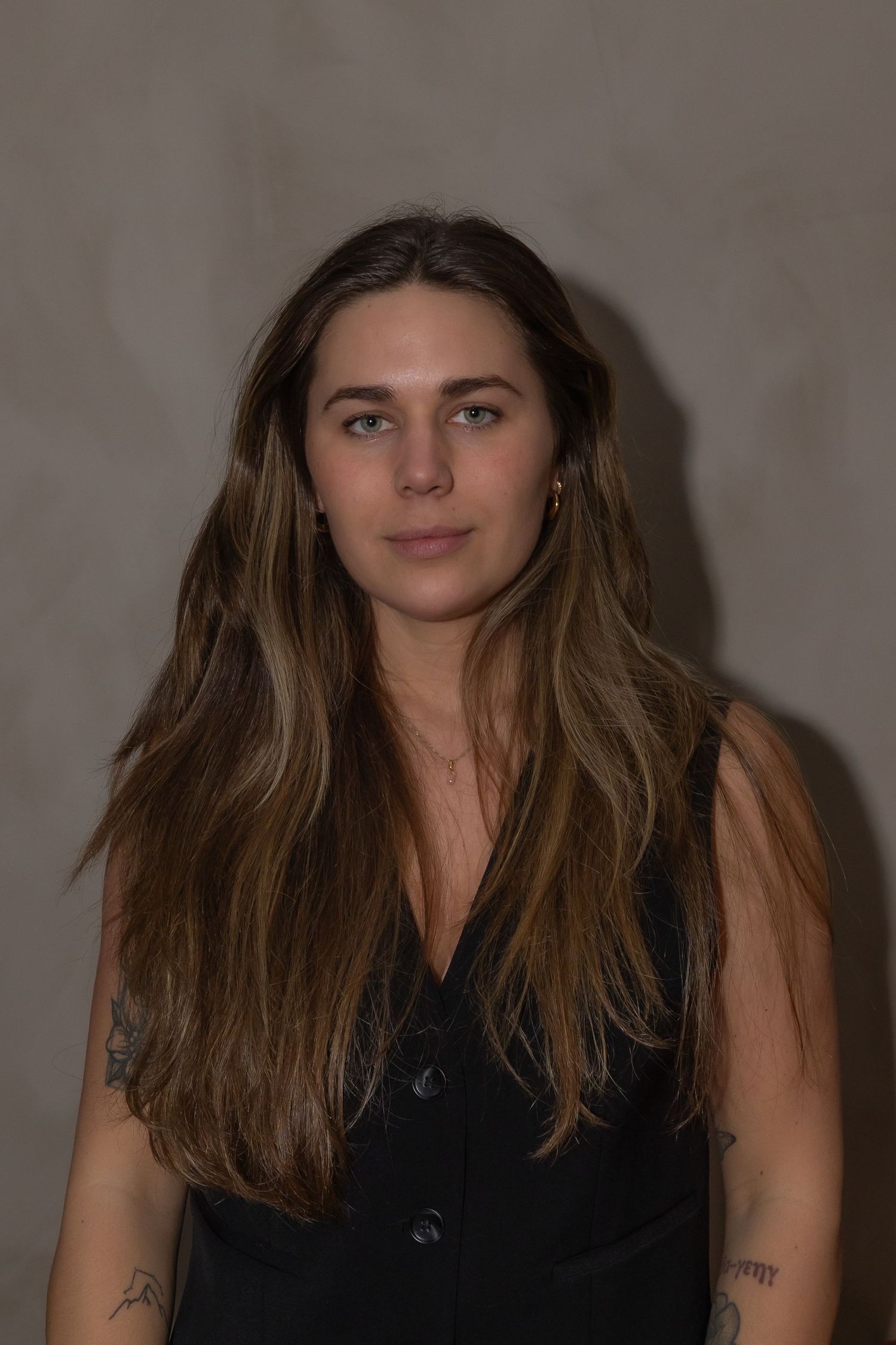 A series of portrait photos showing someone with long brown hair wearing a black sleeveless top against a neutral background.