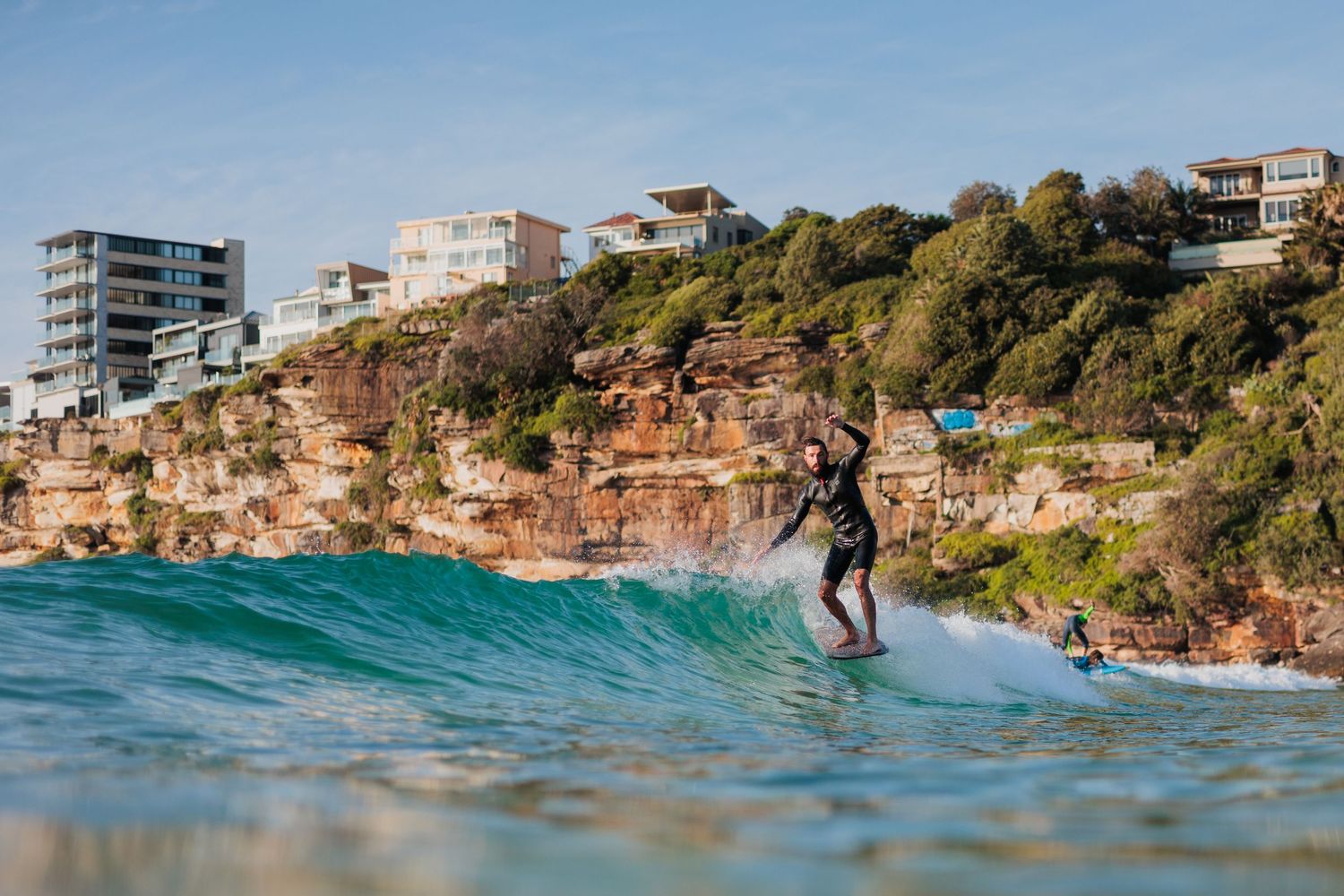 Surfer on a long board, almost hanging 5 at Freshwater Beach