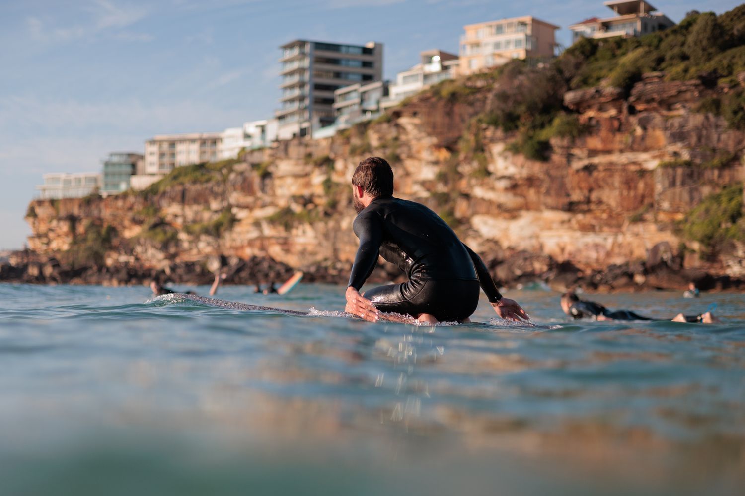Surfer knee paddling a longboard at Freshwater beach