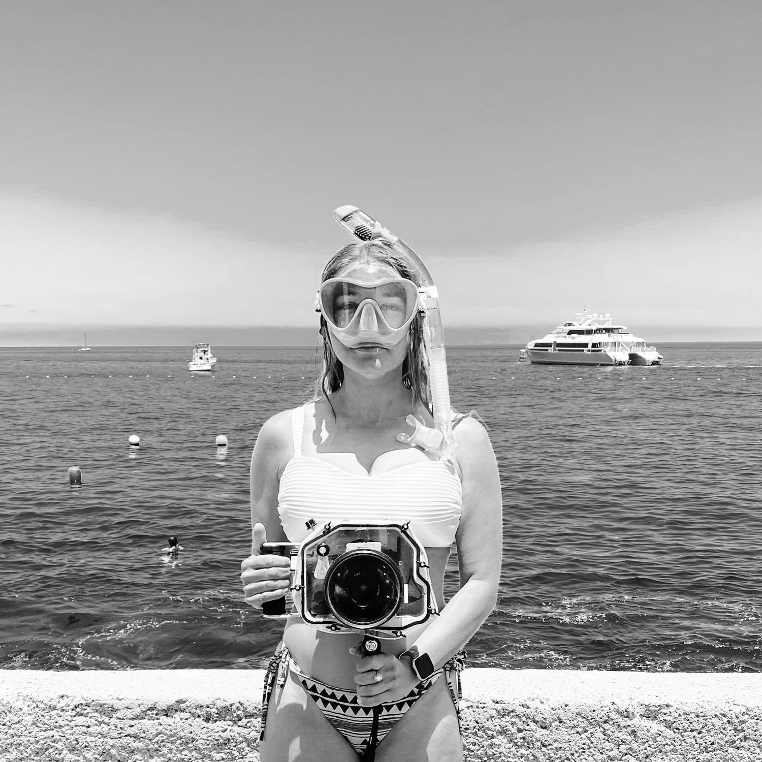 A series of black and white photographs showing people enjoying activities on a boat and in the ocean.