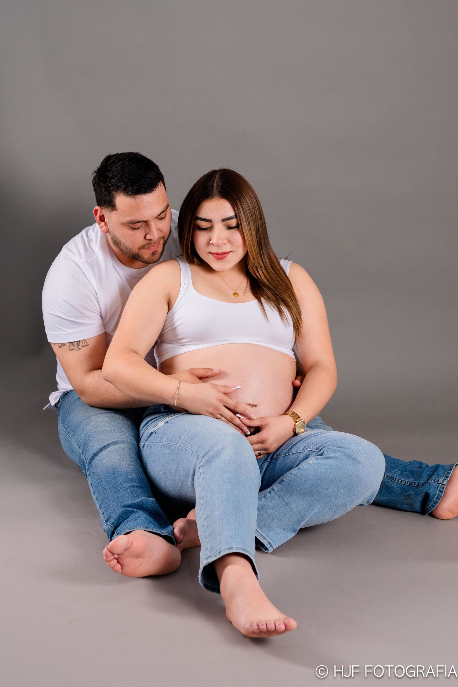 Sesión de embarazo con pareja mirando la pancita con amor y ternura