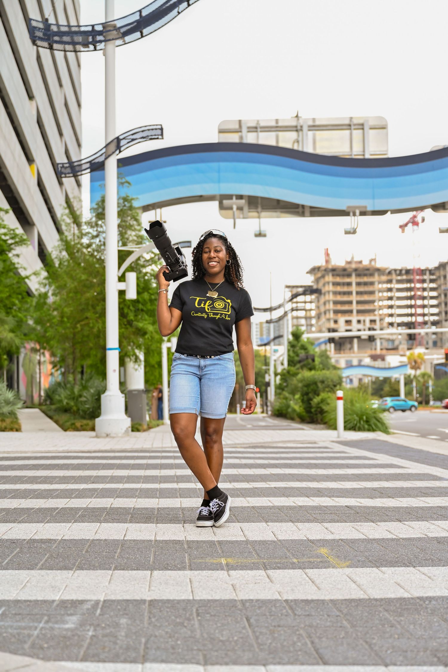 Tiffany Jones smiling and holding a camera during a portrait session in Tampa, Florida, photographed by Blue Lime Photo Media