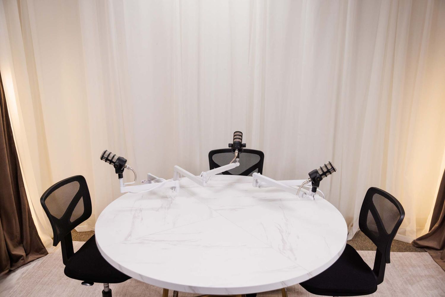 Three-person podcast recording table with microphones at The Pod Life by Lockwood Studios in Seminole FL
