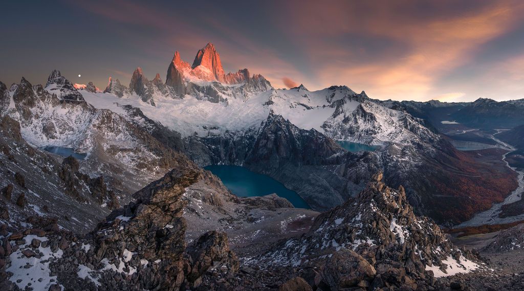 Breathtaking sunrise panorama of Mount Fitz Roy with glacial lake in Patagonian wilderness.