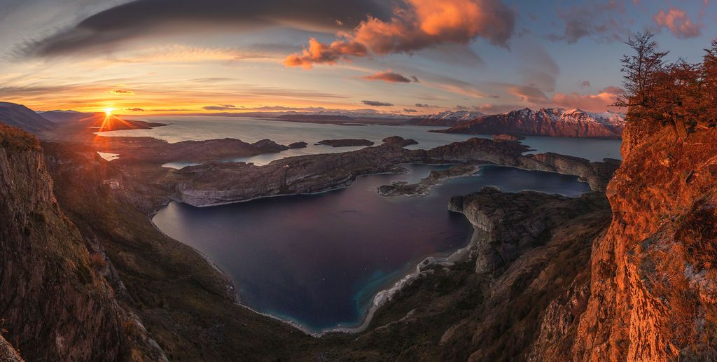 Stunning sunset panorama of fjords and islands viewed from rocky cliffs in Patagonia.