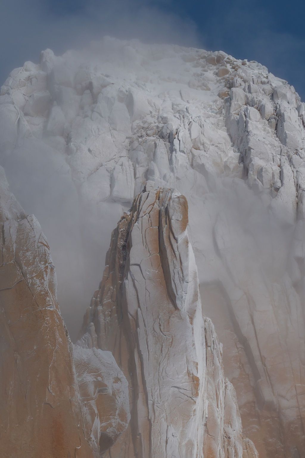 Close-up of snow-covered granite spires with swirling mist and ice on Cerro Torre, Patagonia.