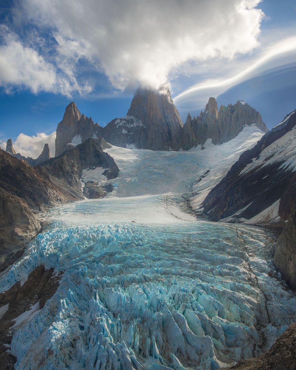 Stunning aerial view of blue glacial ice below the iconic spires of Mount Fitz Roy.