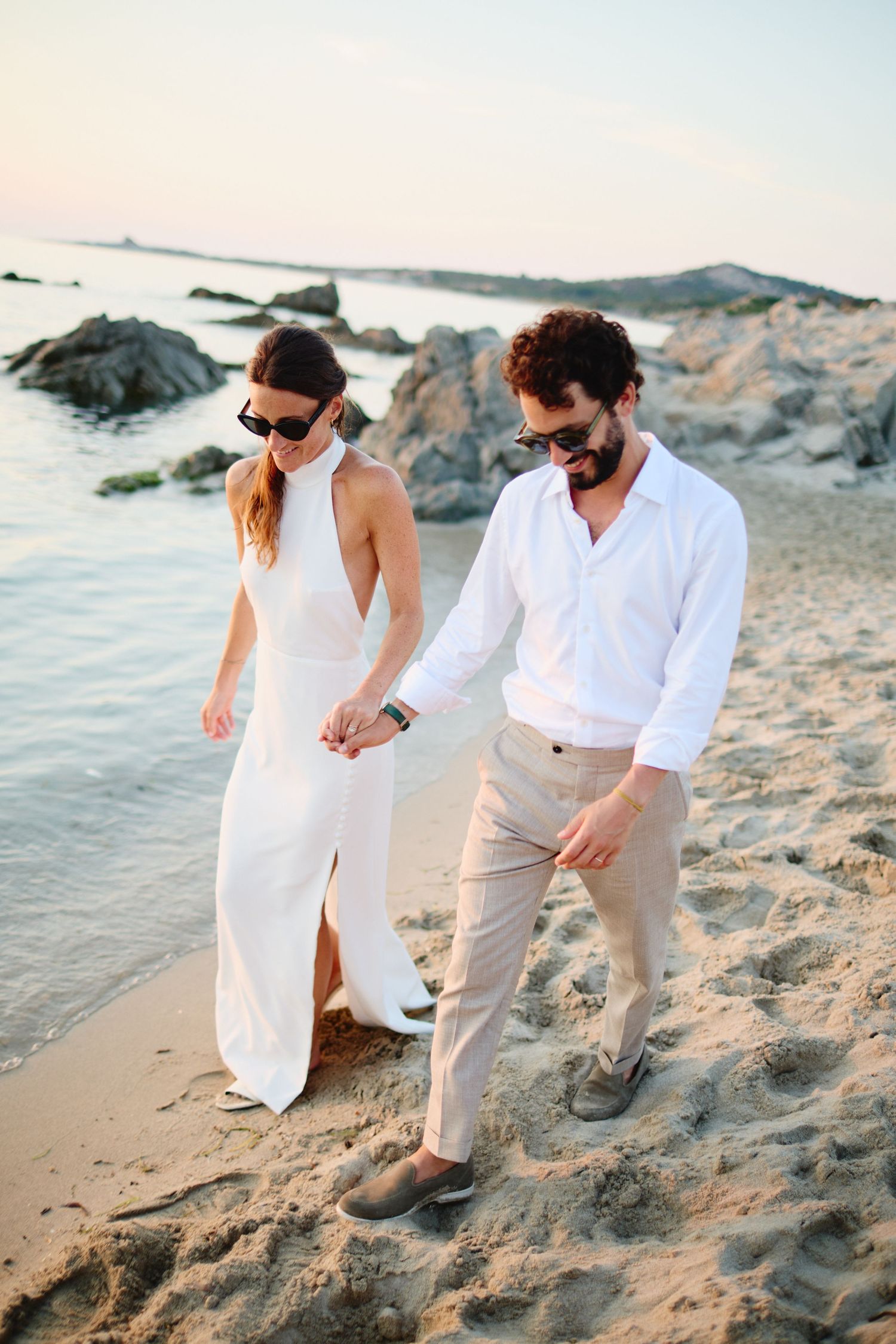 Couple marchant sur la plage du Pain de Sucre à Lumio au coucher du soleil.