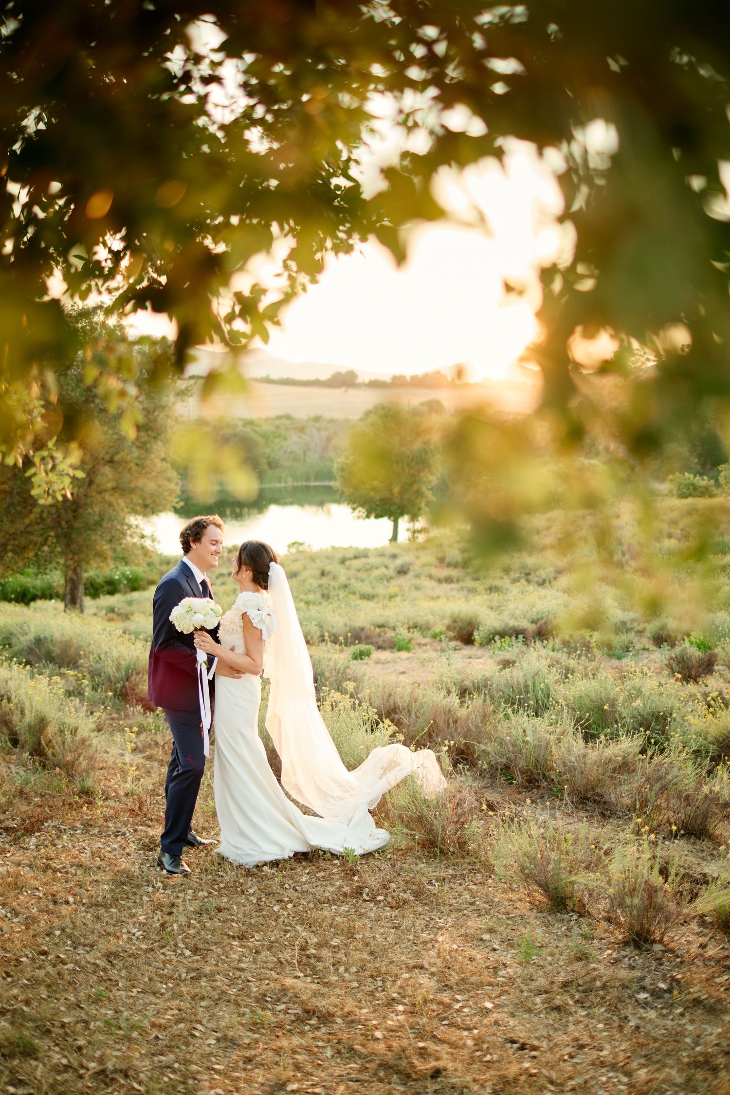 Couple de mariés dans les vignes du Domaine Terra d'Oru au coucher du soleil.