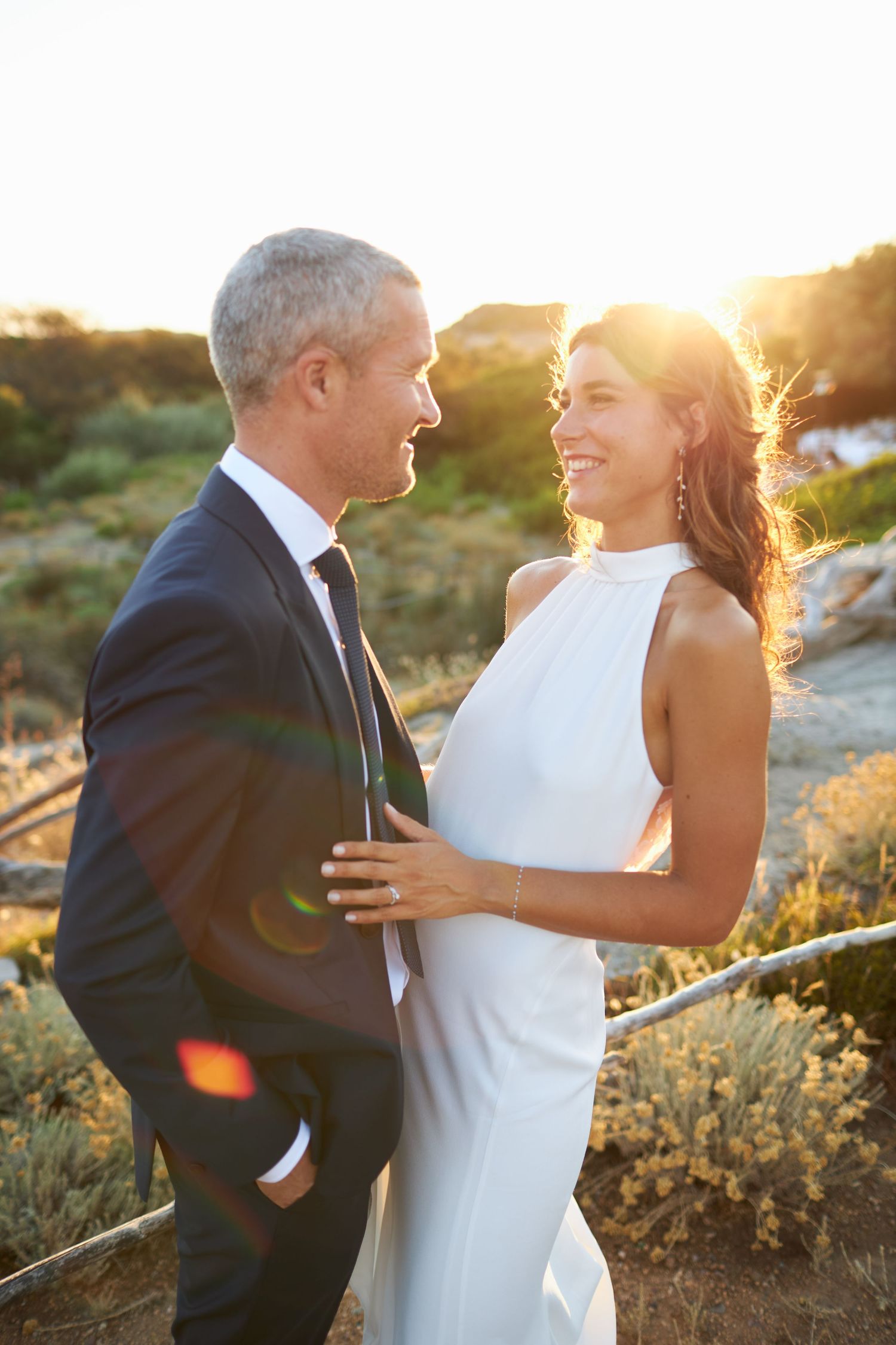 Bride and groom sharing a romantic moment at sunset during an outdoor beach wedding.