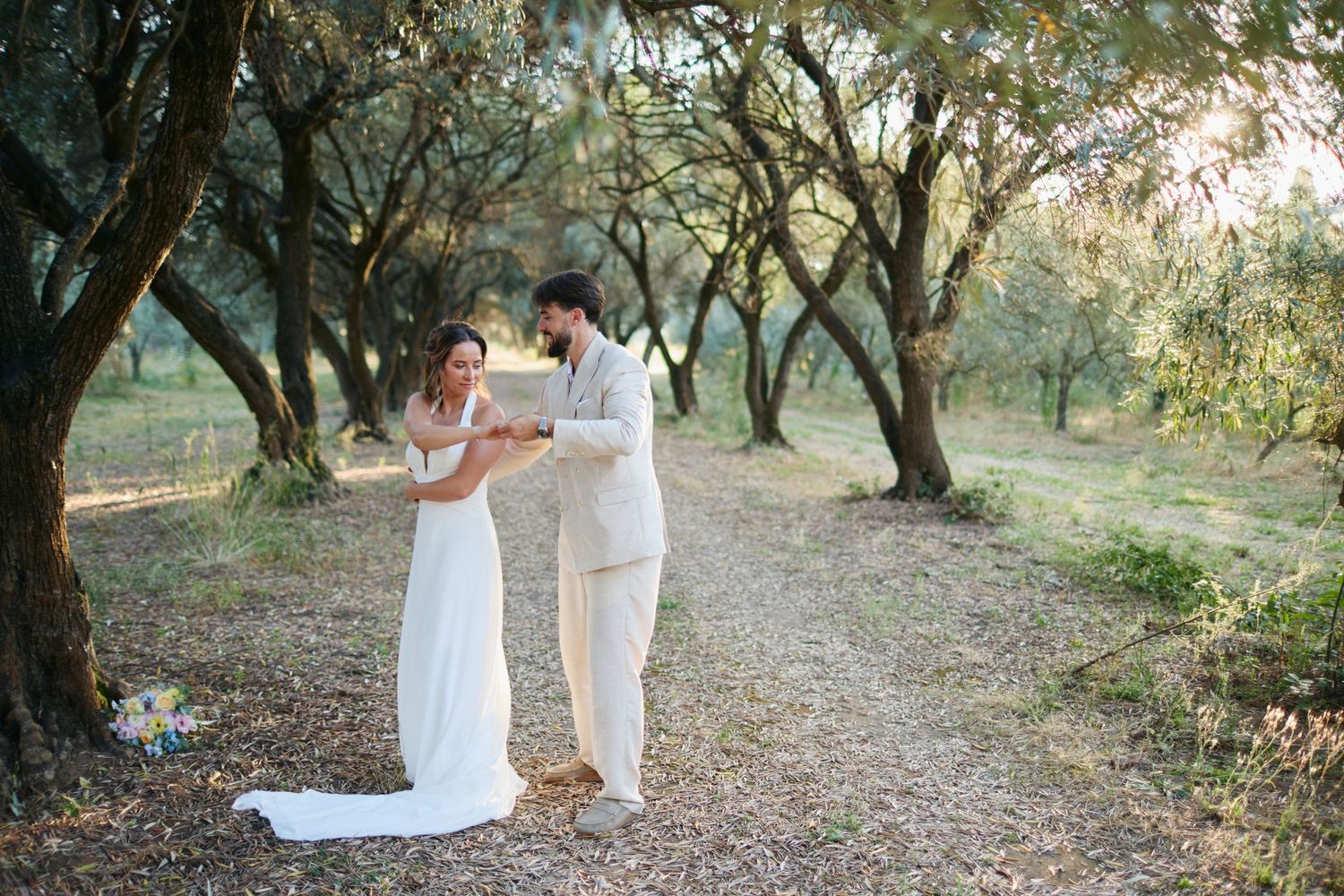 Bride and groom exchange vows reading from book in olive tree grove.