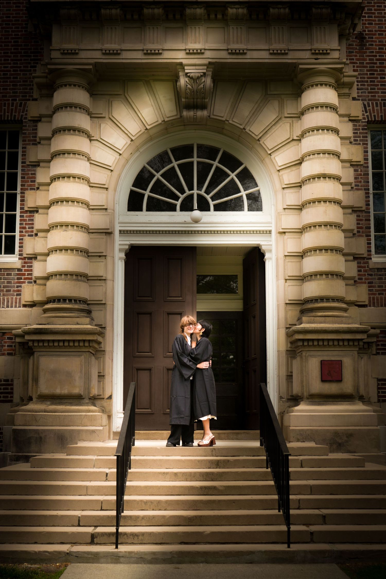 Portrait of a couple kissing outside a building.