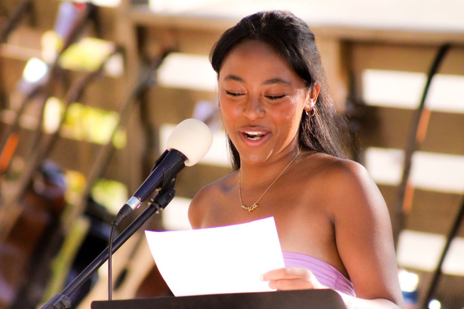 A woman giving a speech into a mic.