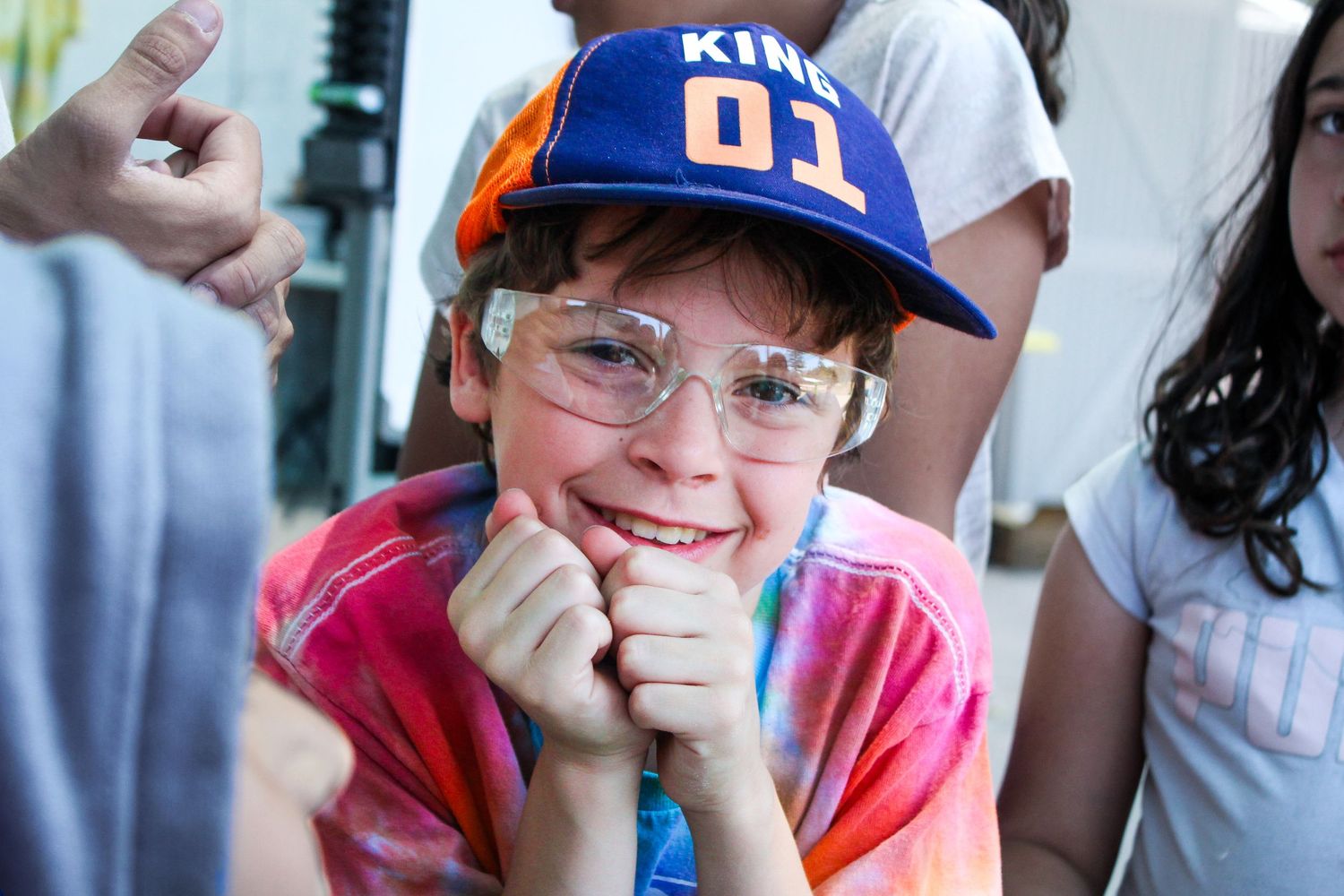 A boy with goggles on smiling into the camera.