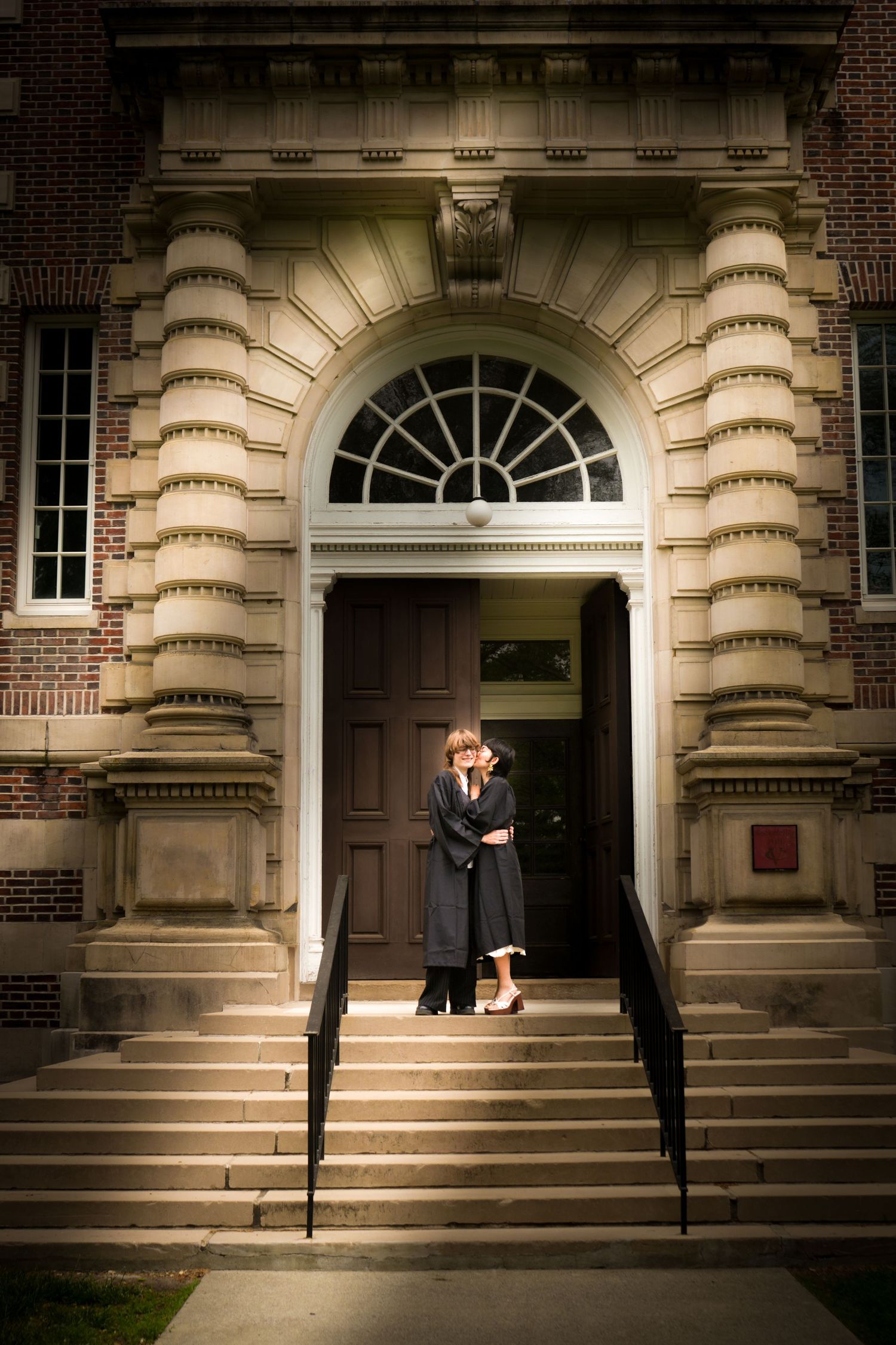 Portrait of a couple kissing outside a building.