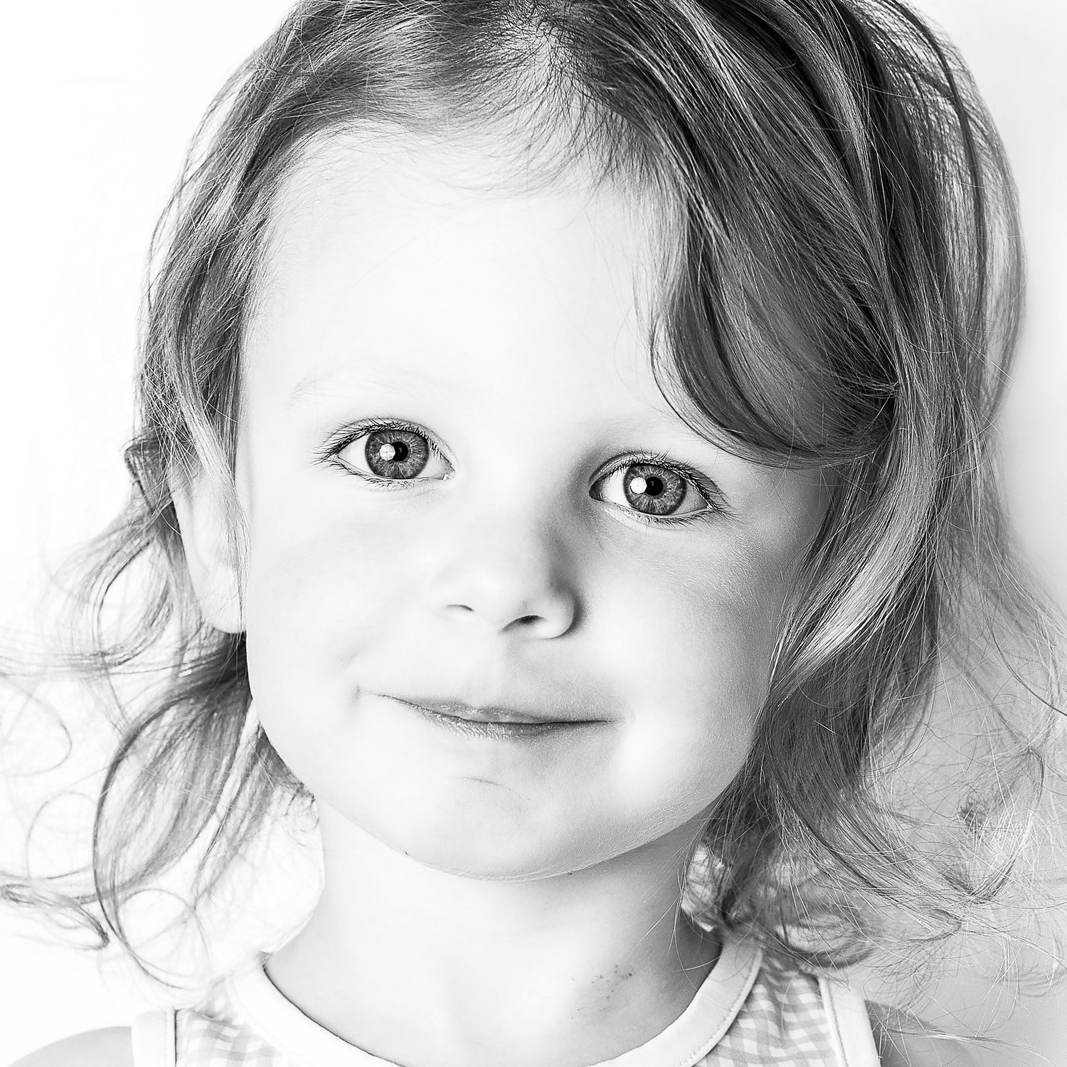 Black-and-white portrait of smiling young girl at Classic Littles children's portrait session.