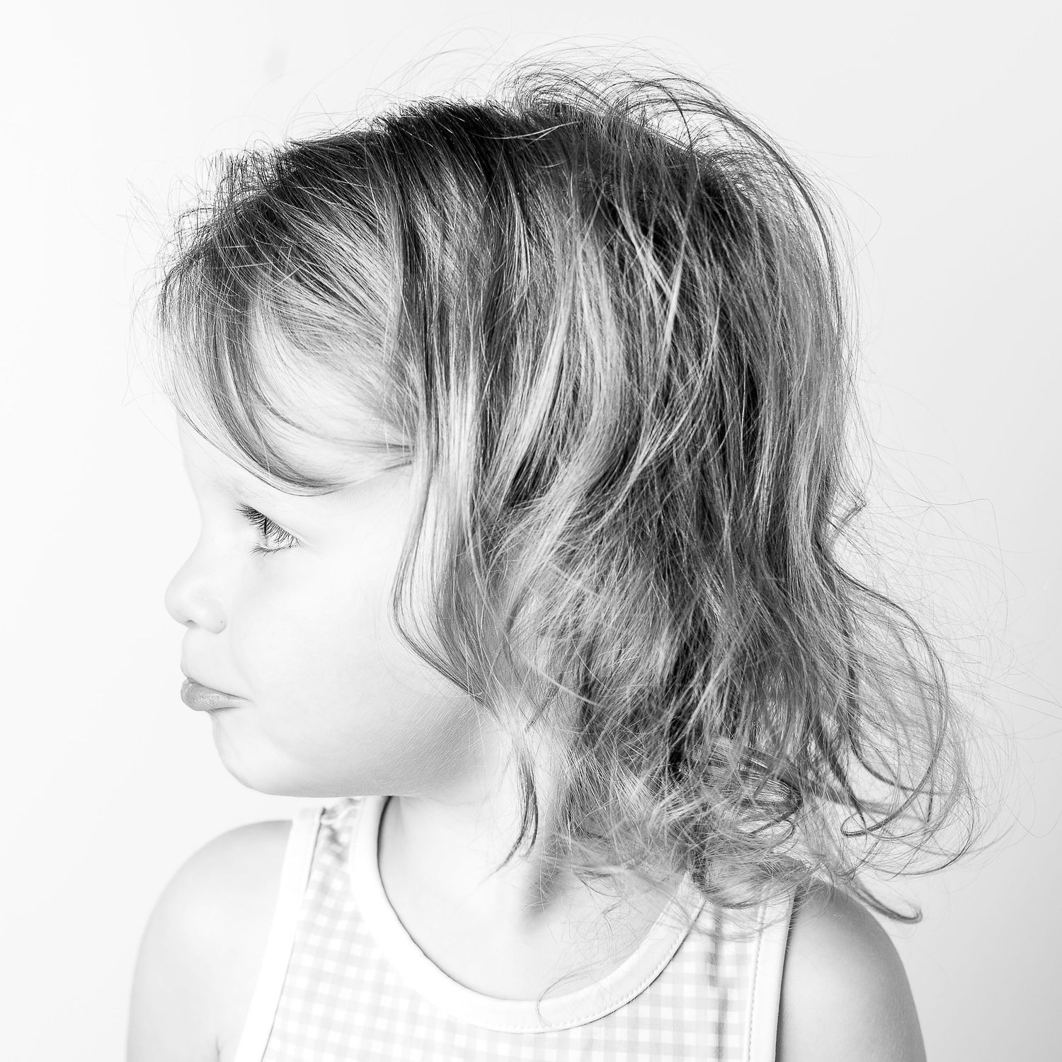 Black-and-white portrait of smiling young girl at Classic Littles children's portrait session.