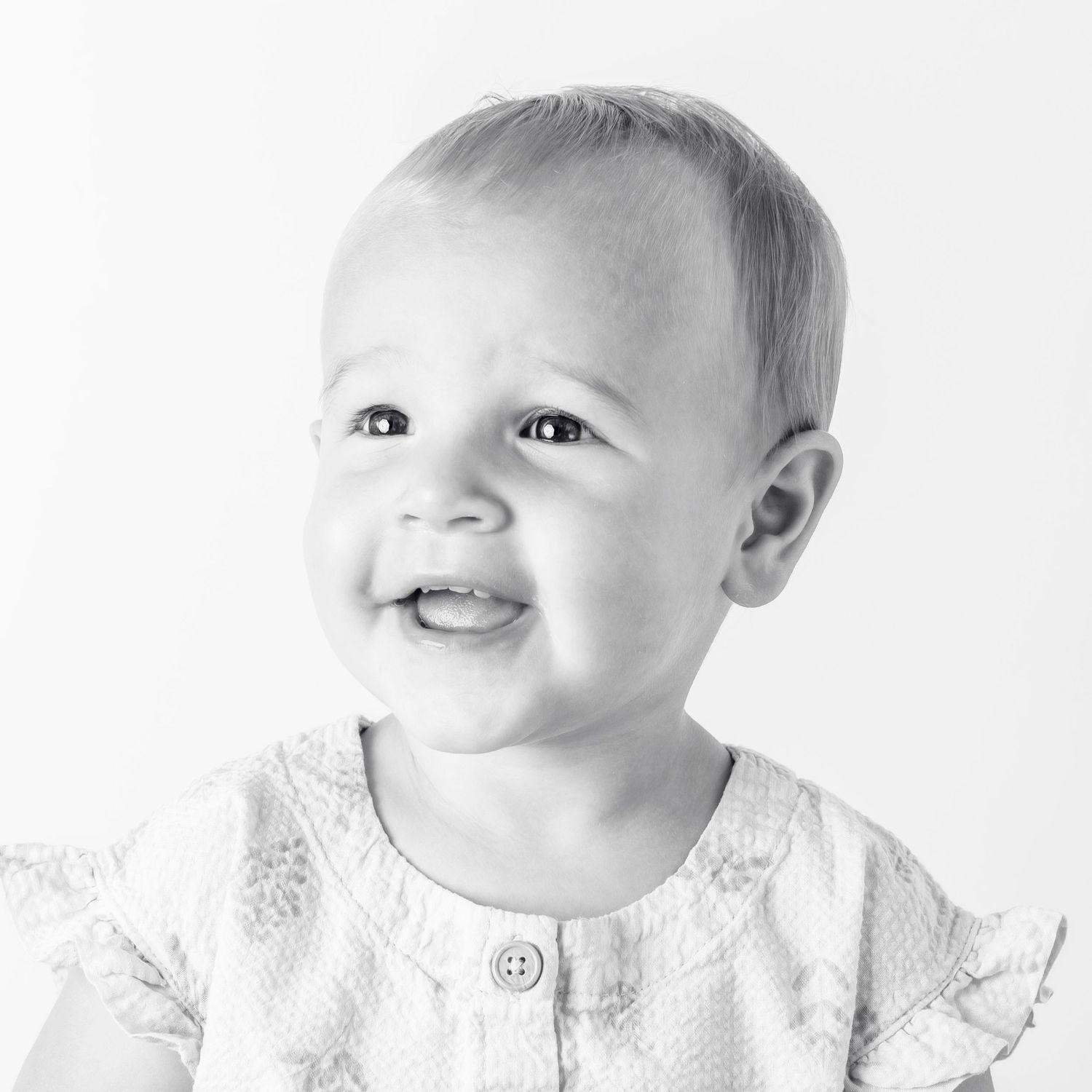 Black-and-white portrait of smiling young girl at Classic Littles children's portrait session.