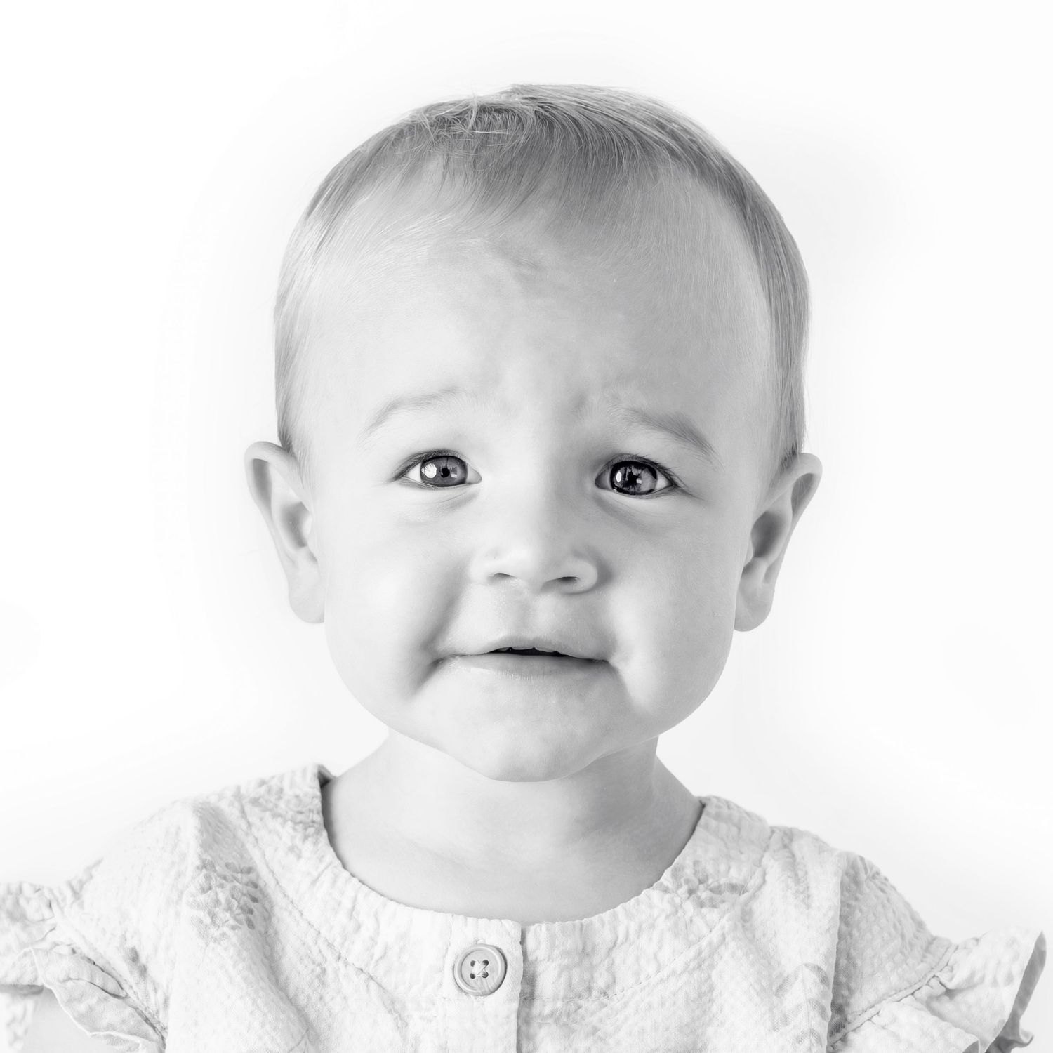 Black-and-white portrait of smiling young girl at Classic Littles children's portrait session.