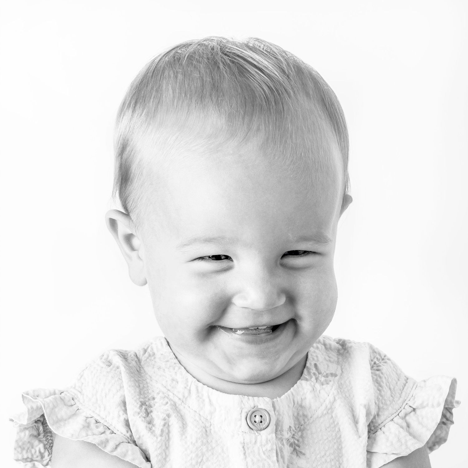 Black-and-white portrait of smiling young girl at Classic Littles children's portrait session.