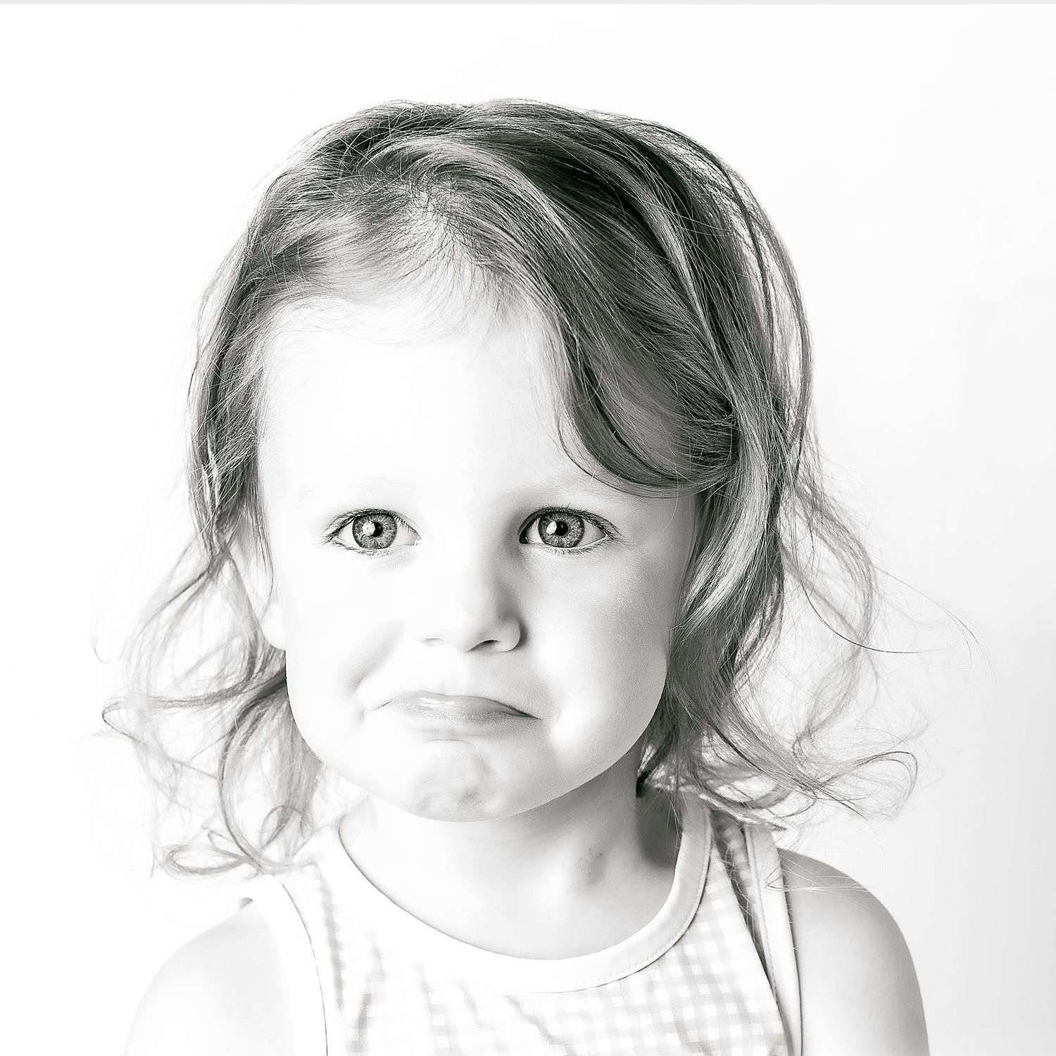 Black-and-white portrait of smiling young girl at Classic Littles children's portrait session.
