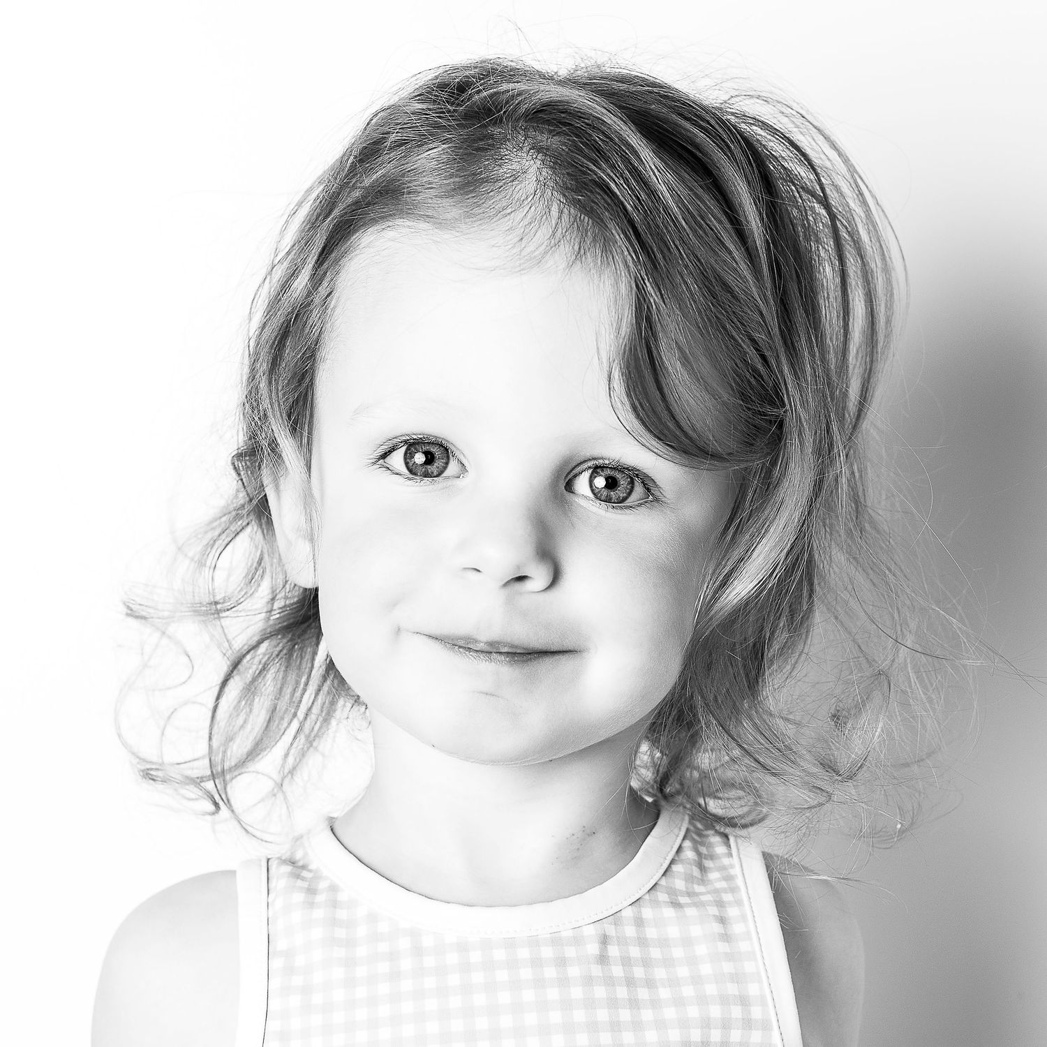 Black-and-white portrait of smiling young girl at Classic Littles children's portrait session.