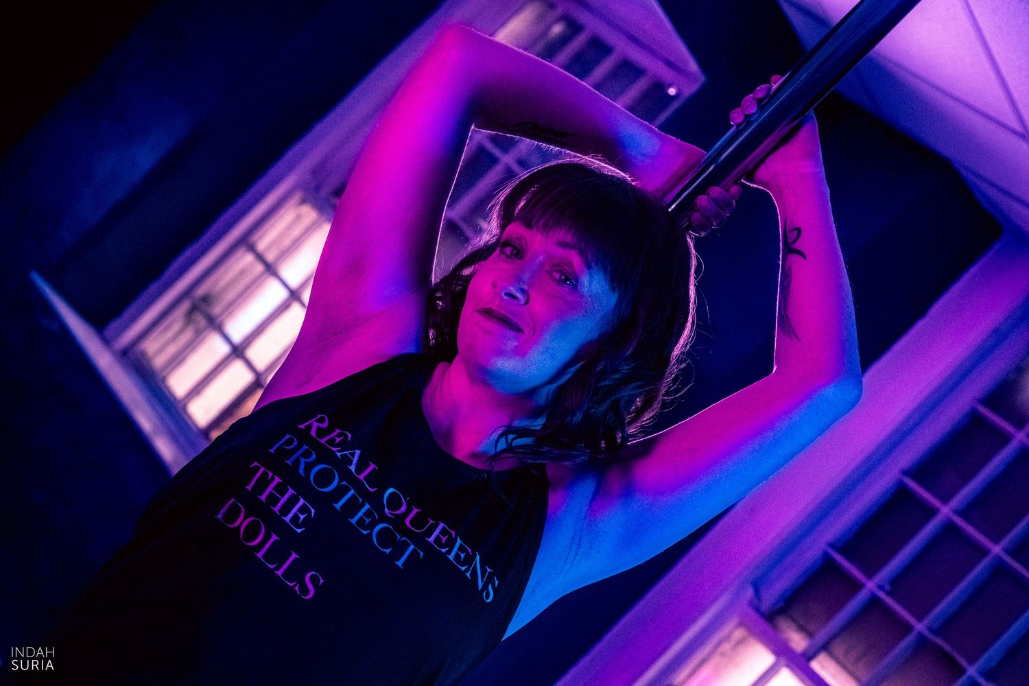 Pole dance photography where the dancer is posed in front of the pole.