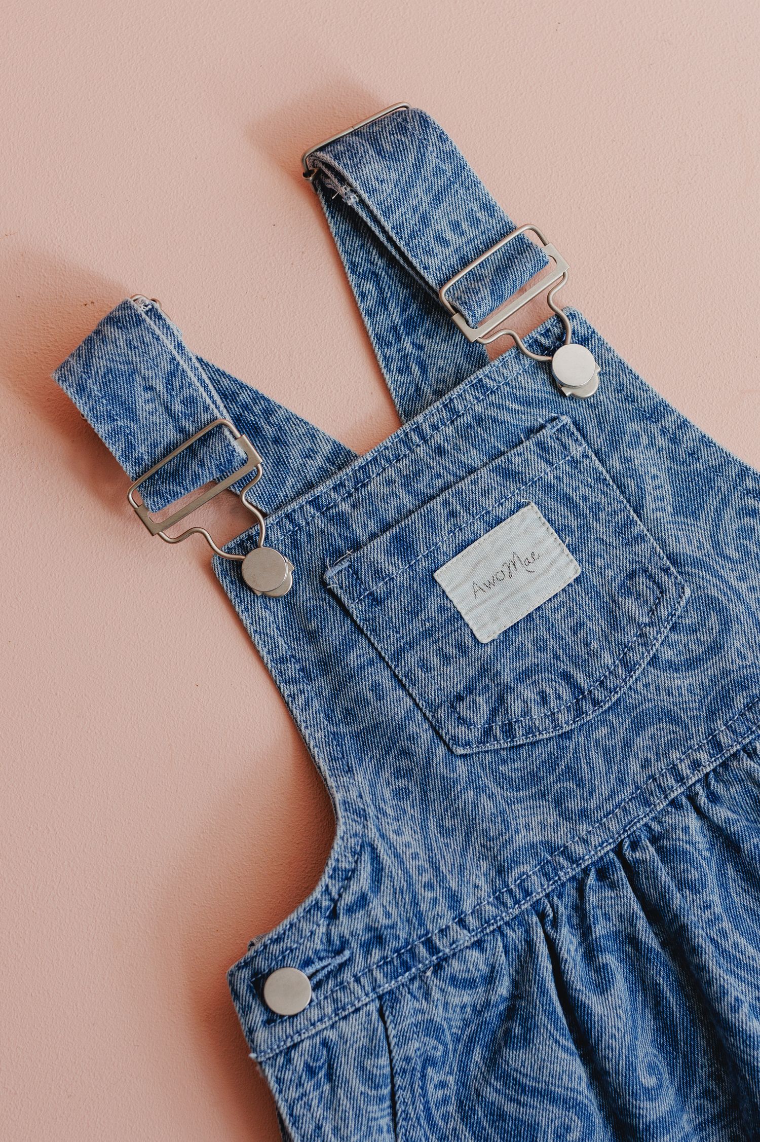 Vintage denim overalls with paisley pattern detail and silver buttons.