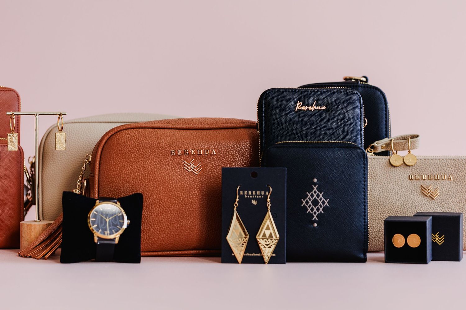 Collection of leather pouches and jewelry cases in navy and brown with gold accents.