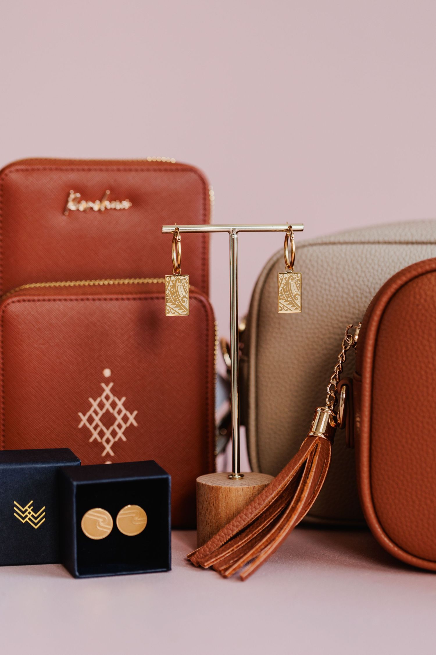 Leather accessories collection featuring earrings, wallets and tassels in brown and beige tones.