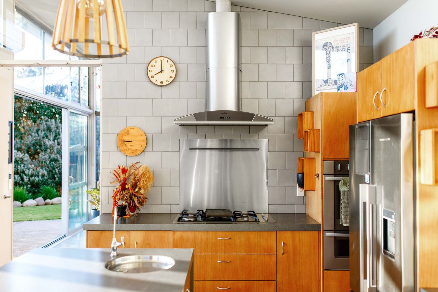 Modern kitchen with wooden cabinets, stainless steel appliances and white subway tile backsplash.