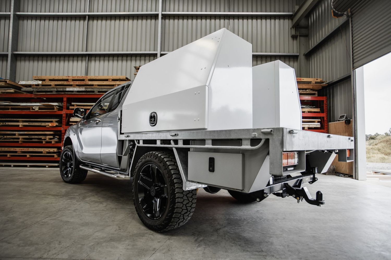 White cargo trailer parked inside an industrial warehouse space.