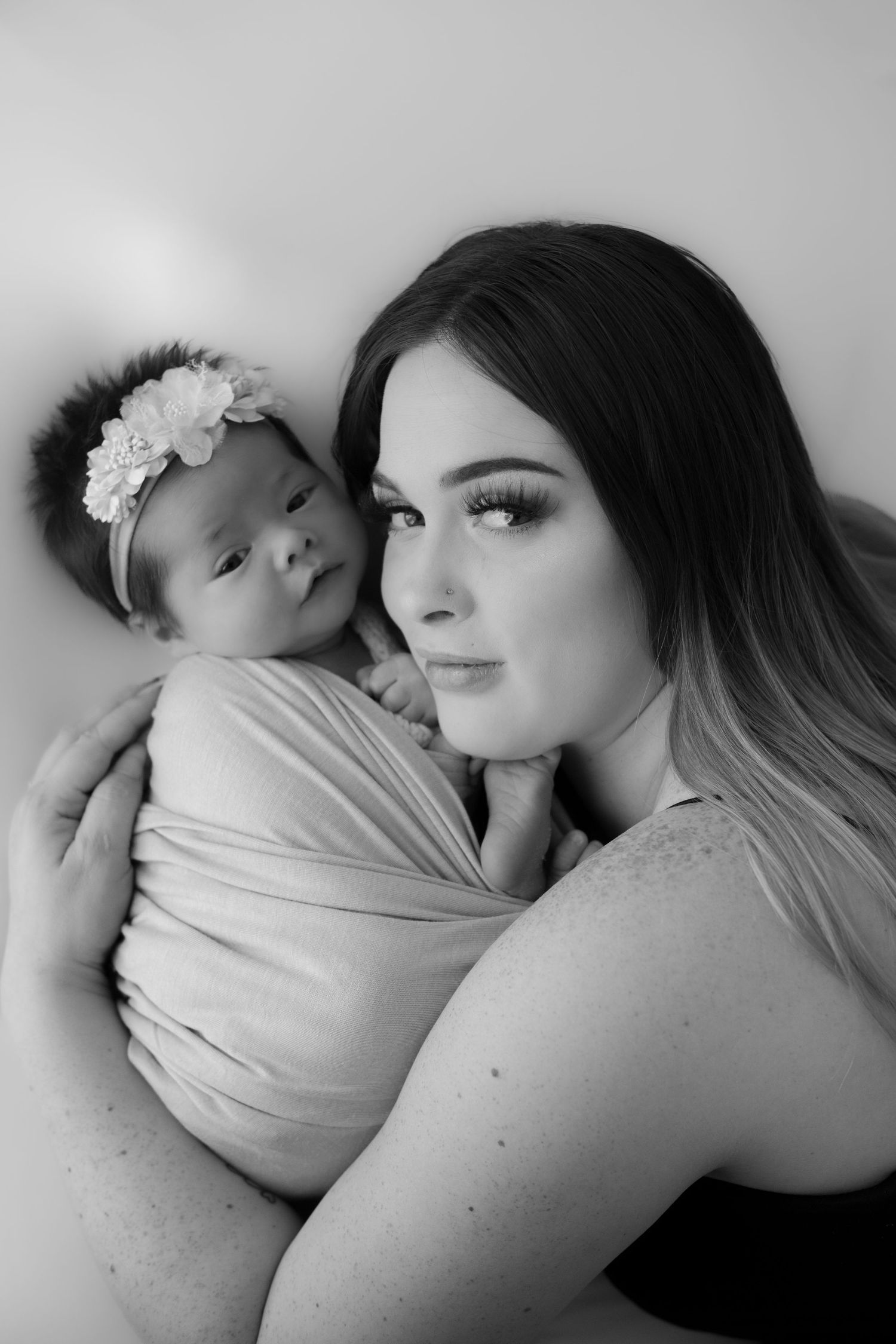 Mother embracing her newborn baby in a timeless portrait.