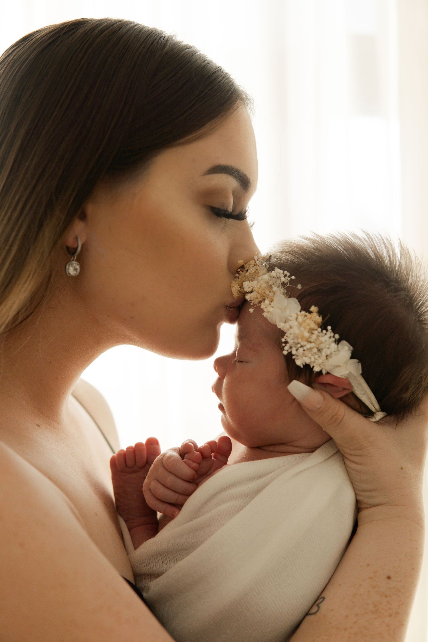 Mother kissing her newborn baby during a natural newborn photography session in Melbourne by Sala Baby Studio.