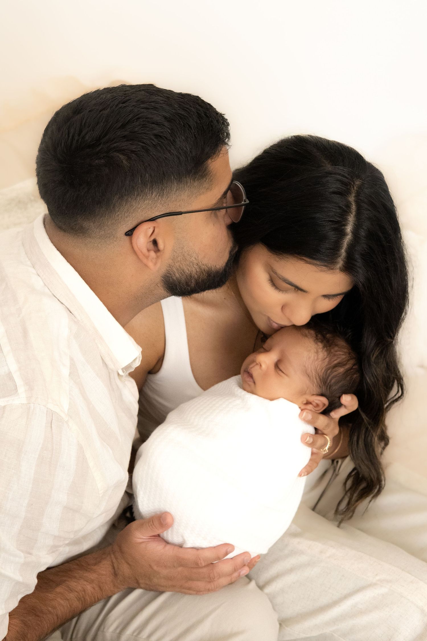 New parents sharing a quiet moment with their newborn baby.